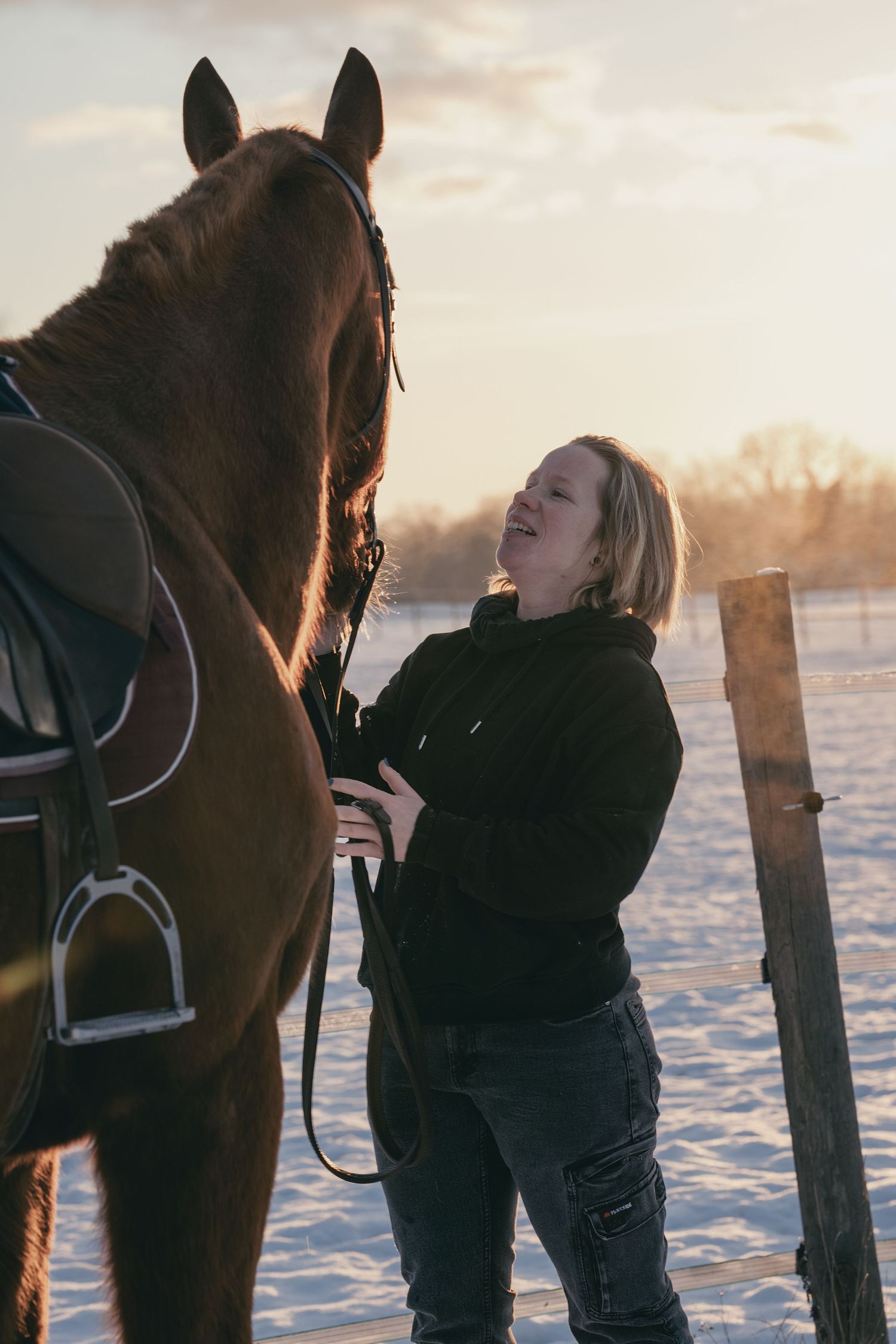 Portrait photo d’Portrait d’une cavalière avec son cheval en lumière naturelleune personne posant avec son cheval