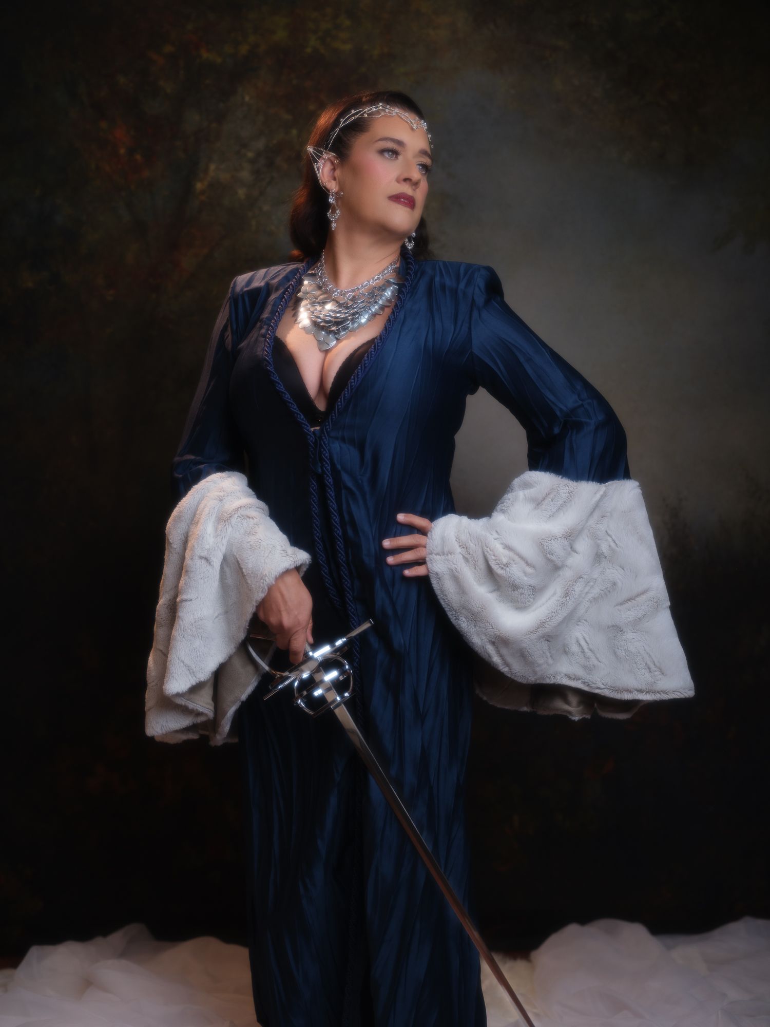 A series of fantasy-inspired photos featuring a flowing navy dress and medieval styling.