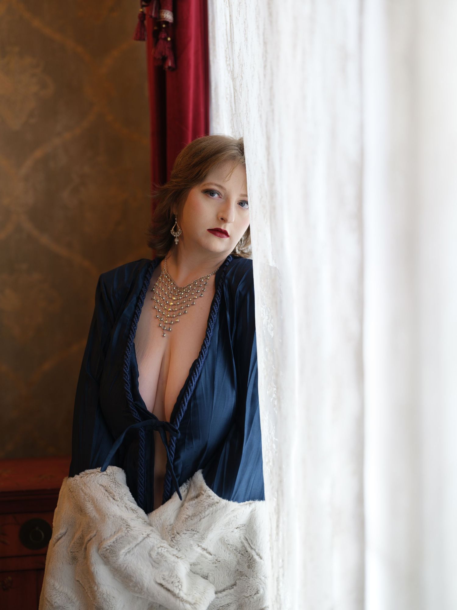 Elegant portrait series in navy blue and white near a window with vintage jewelry styling.