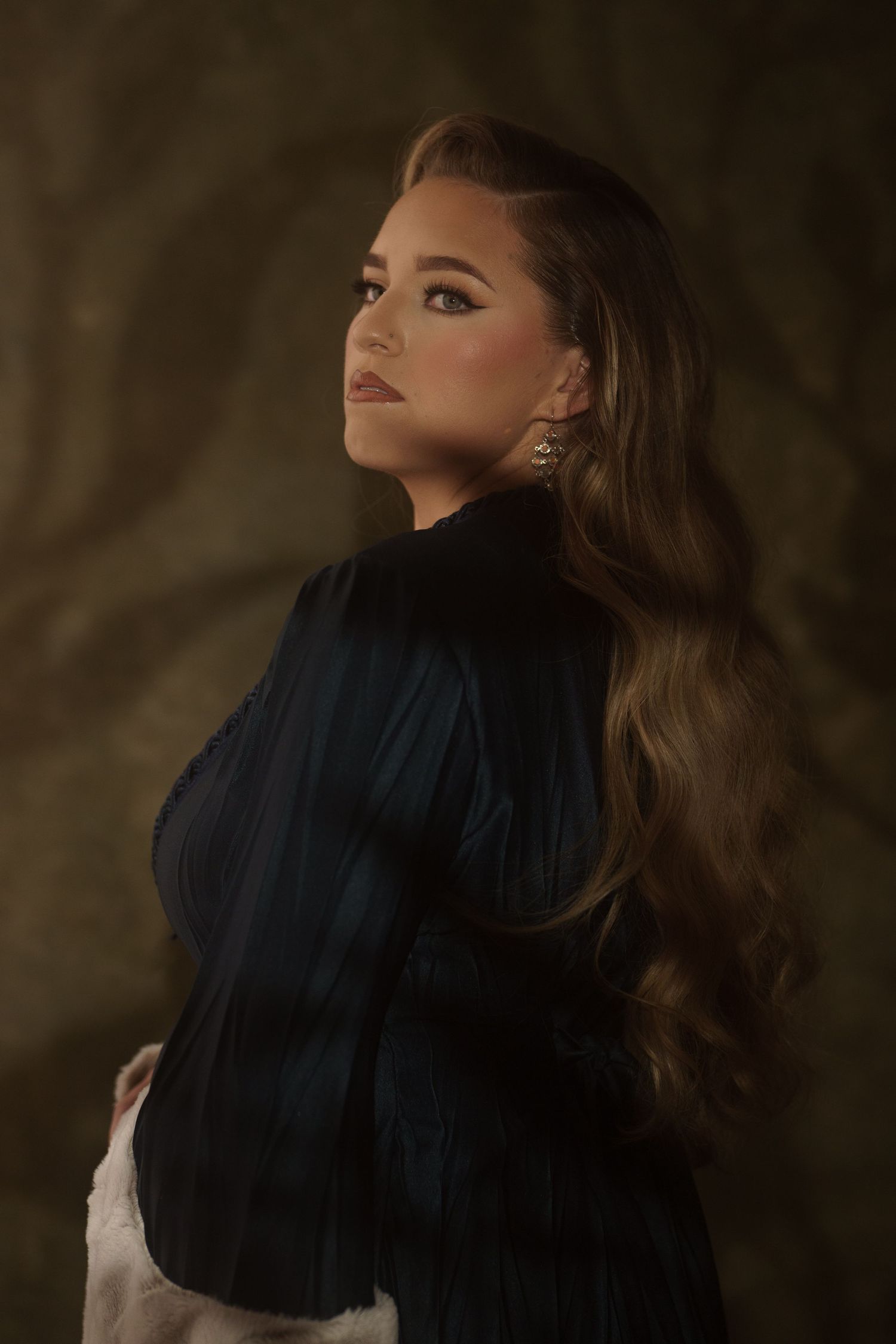 Dramatic portrait series with classic styling and moody lighting against textured background.
