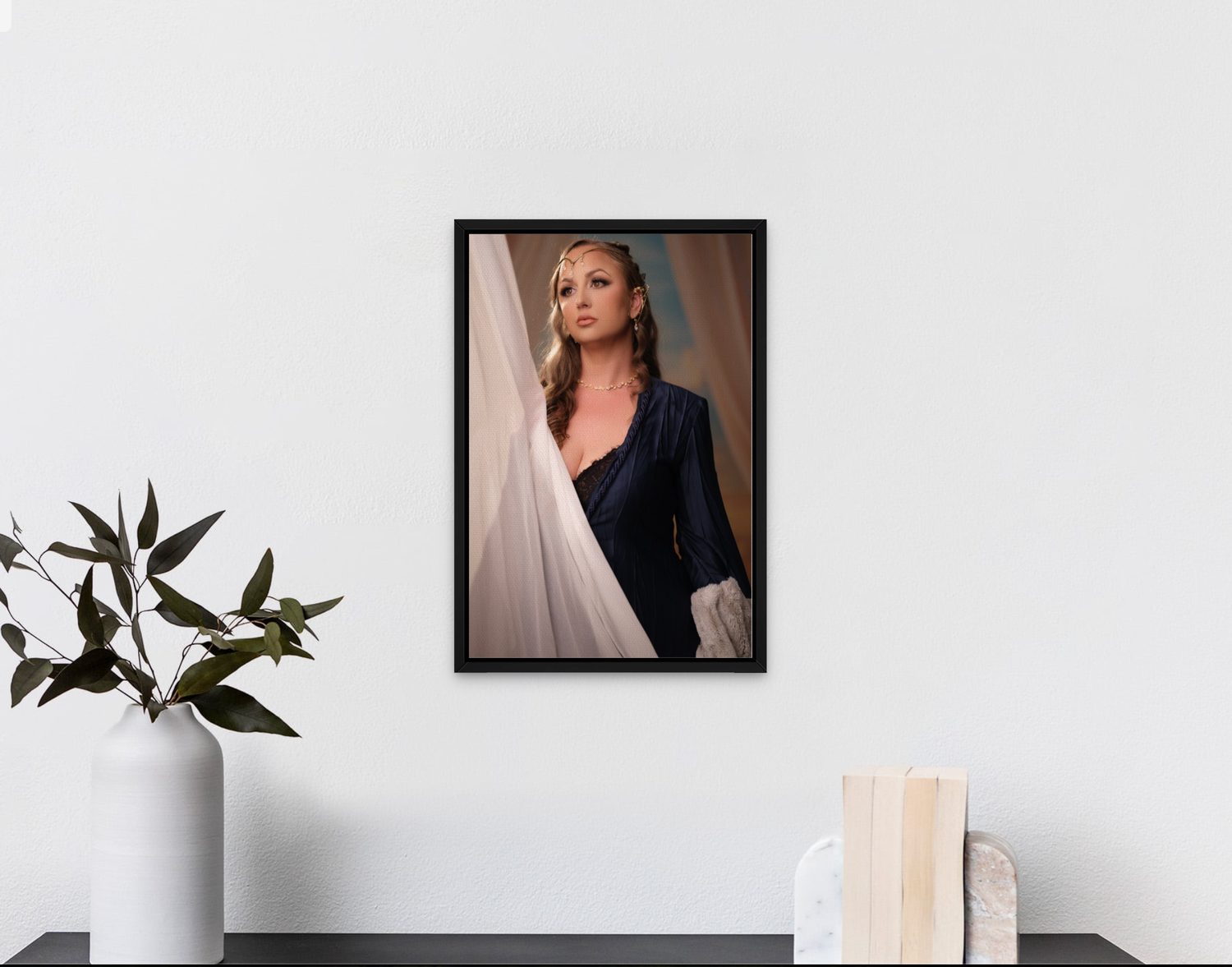 Minimalist gallery wall display with framed portraits and plant decoration.