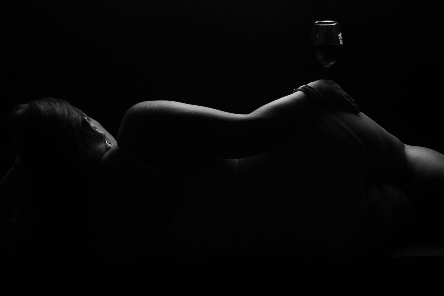 Artistic silhouette showing reclining figure in dramatic low key lighting.