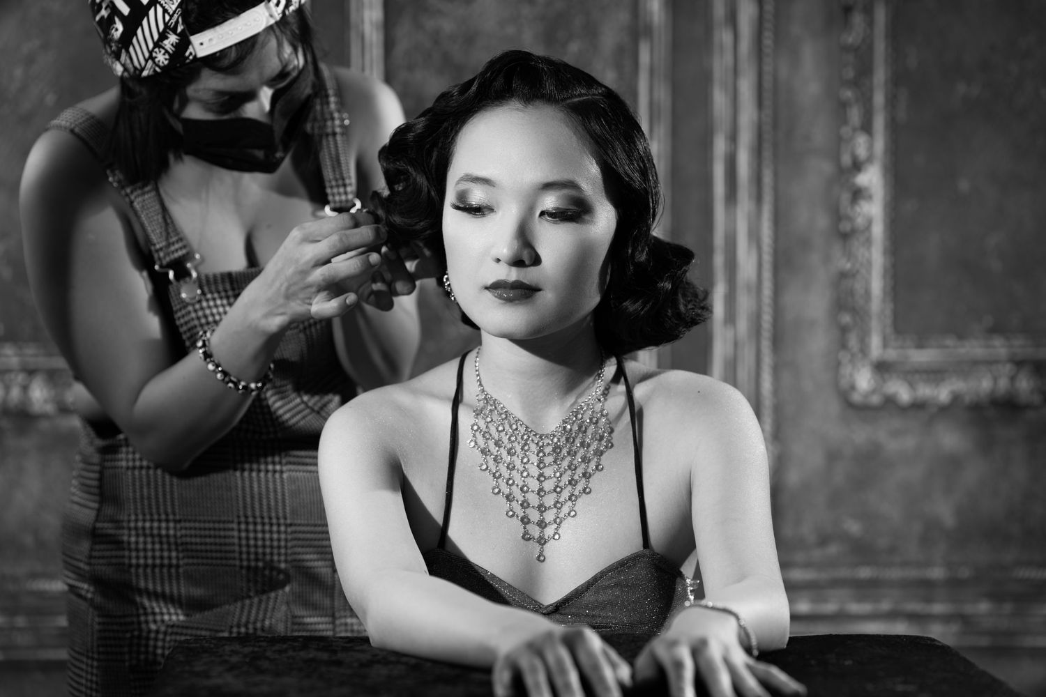 Film noir inspired black and white portrait series with pearl necklace and dramatic shadows.