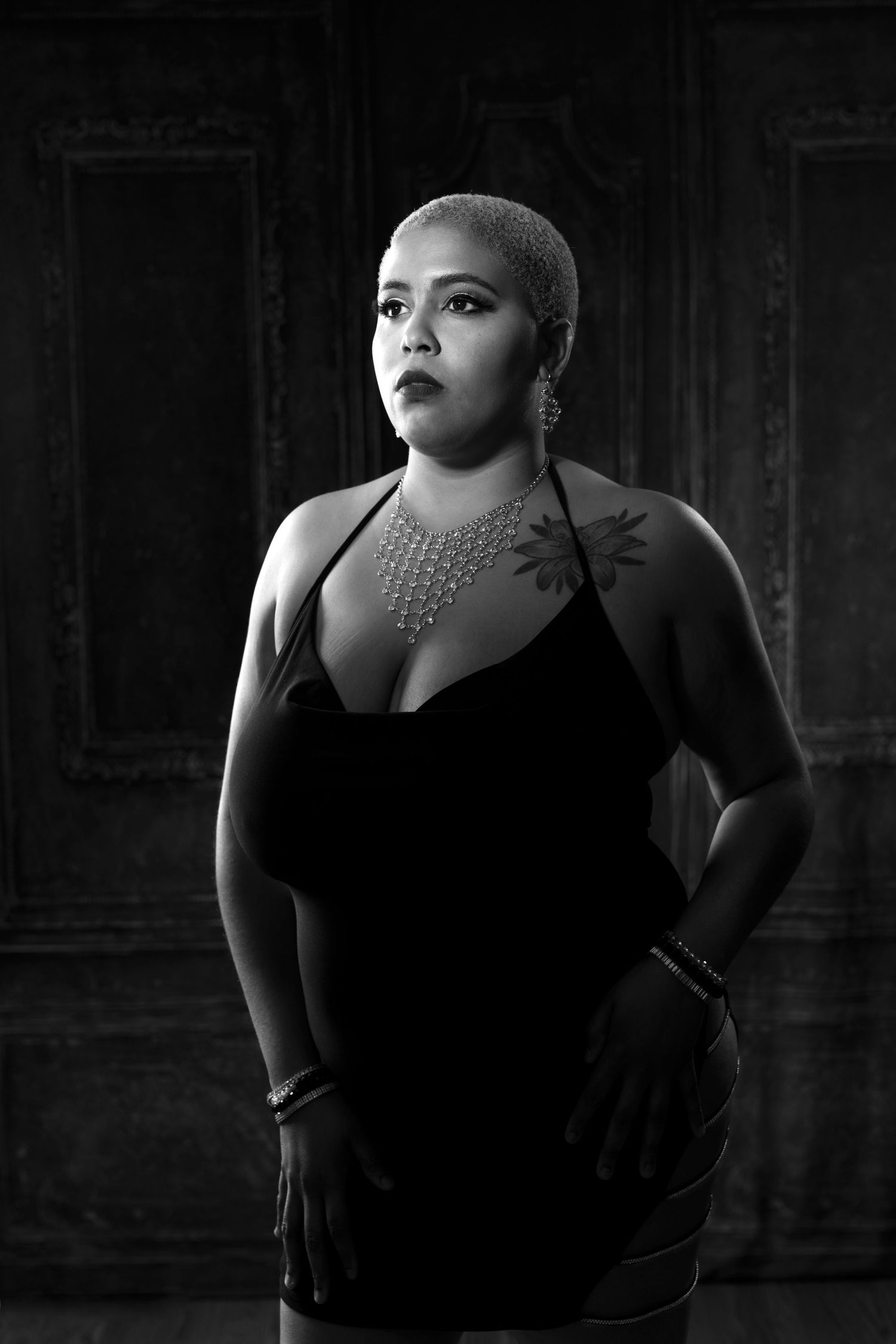 Artistic black and white boudoir photo series featuring dramatic lighting and dark backdrop.