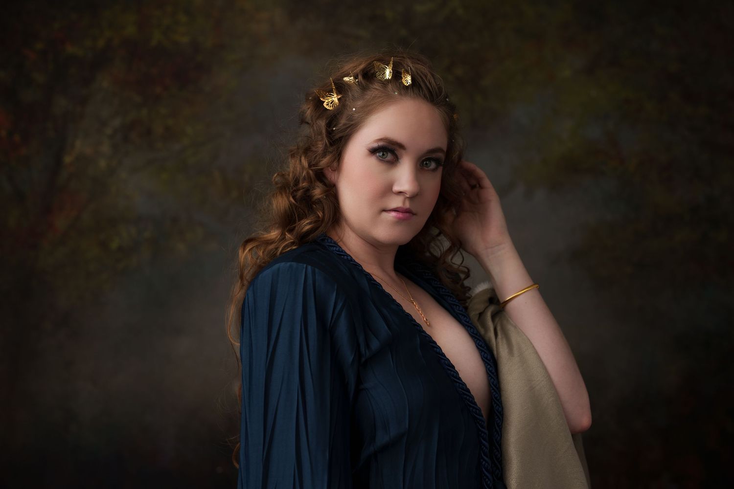 Portrait series in moody lighting with navy blue clothing against dark background.
