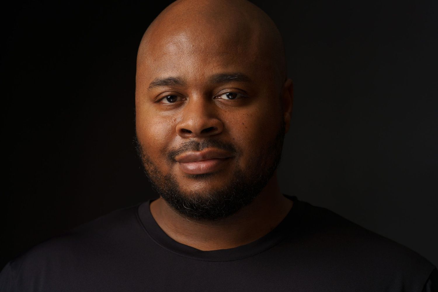 Professional headshots against black background with dramatic side lighting.