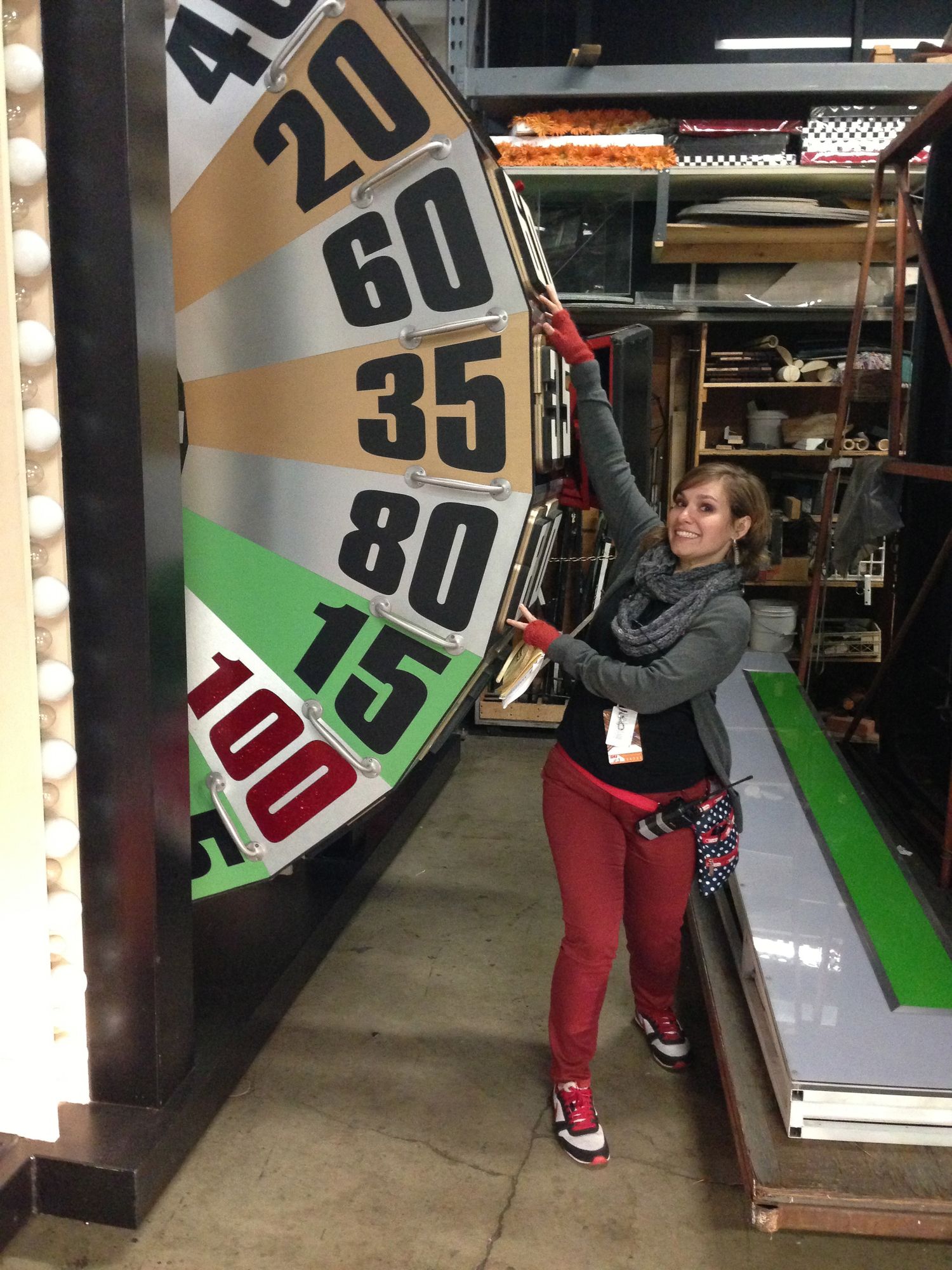 Game show wheel or spinning prize display with illuminated numbers in arcade setting.