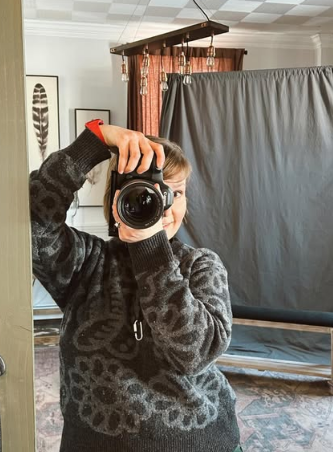 A photographer in a black patterned sweater holds up a camera in a sequence of four progressive shots.