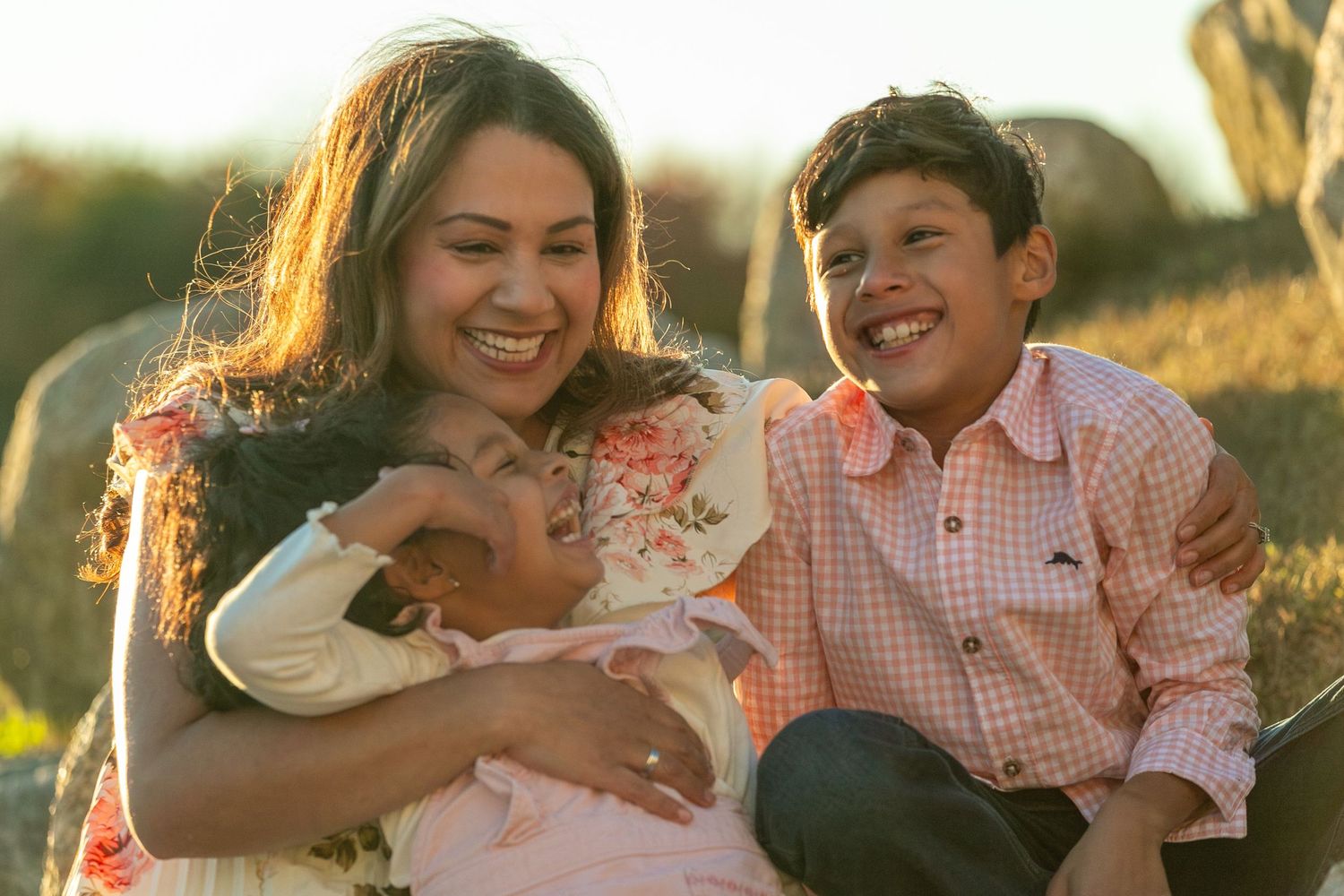 A heartwarming outdoor family moment captured during golden hour with natural garden scenery.