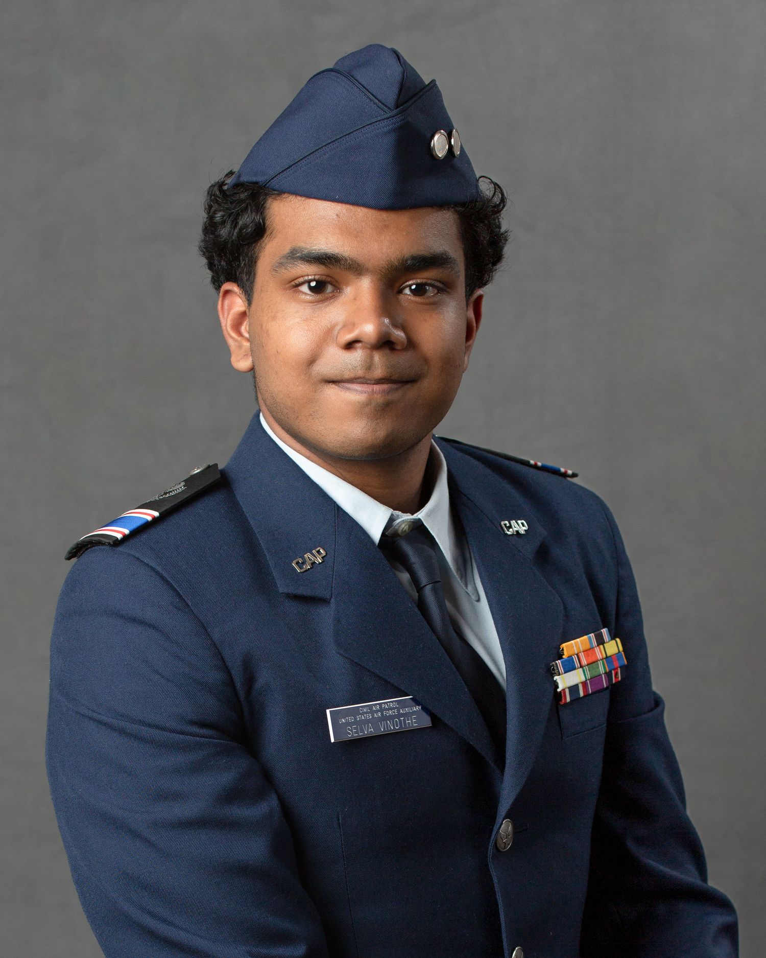 Young man in Civil Air Patrol dress uniform with cap, ribbons, and insignia posing for official portrait.