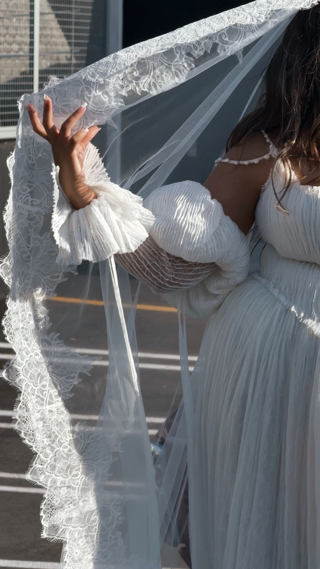 Series of images showing flowing white lace veil against brick building.