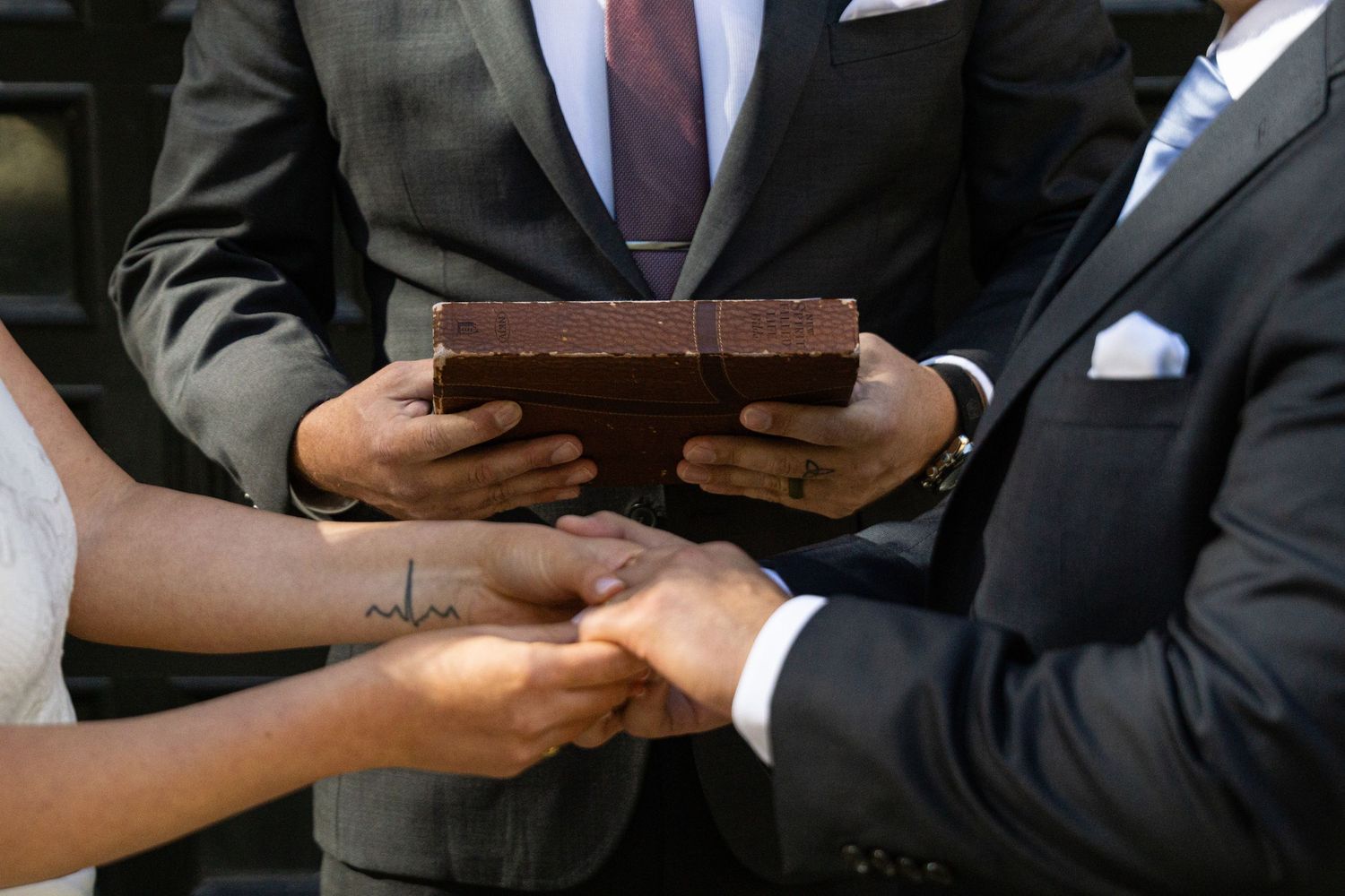 Business people in suits exchanging documents and shaking hands during a formal meeting.