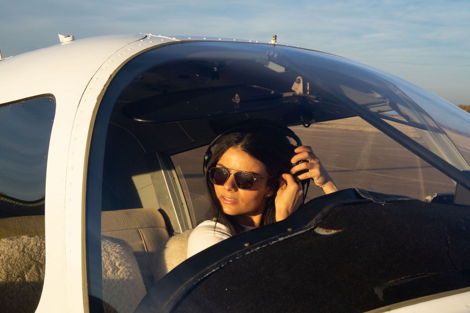 A series of photos showing someone sitting in the driver's seat of a car wearing sunglasses against a blue sky backdrop.