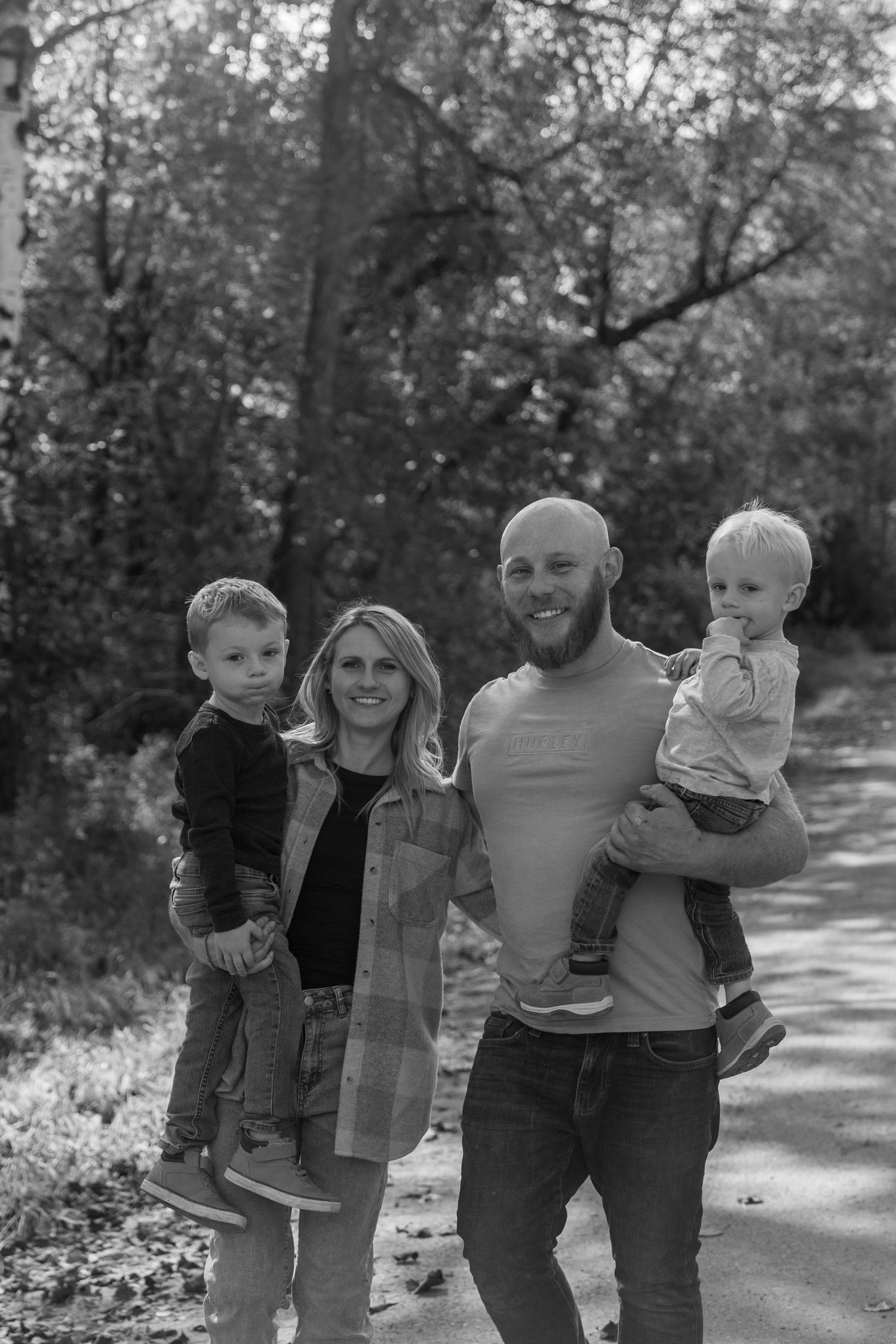 A black and white photo sequence shows a family walking together on a tree-lined path outdoors.