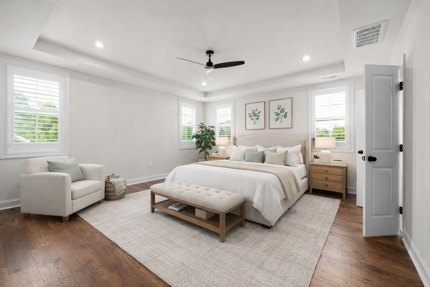 Modern bedroom features white walls, hardwood floors, and large windows creating a bright, airy atmosphere.