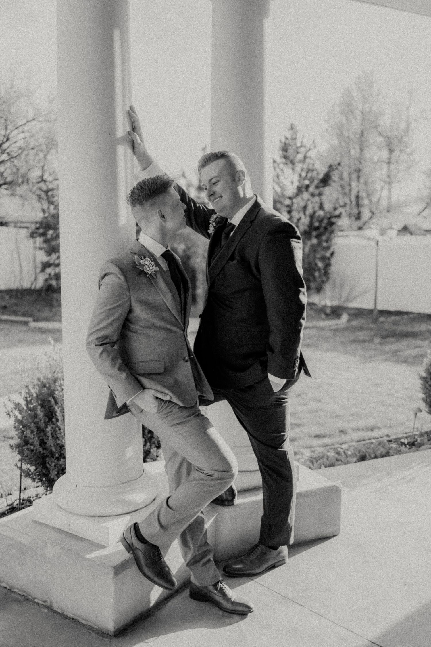 A playful black and white portrait session on a porch with white columns.