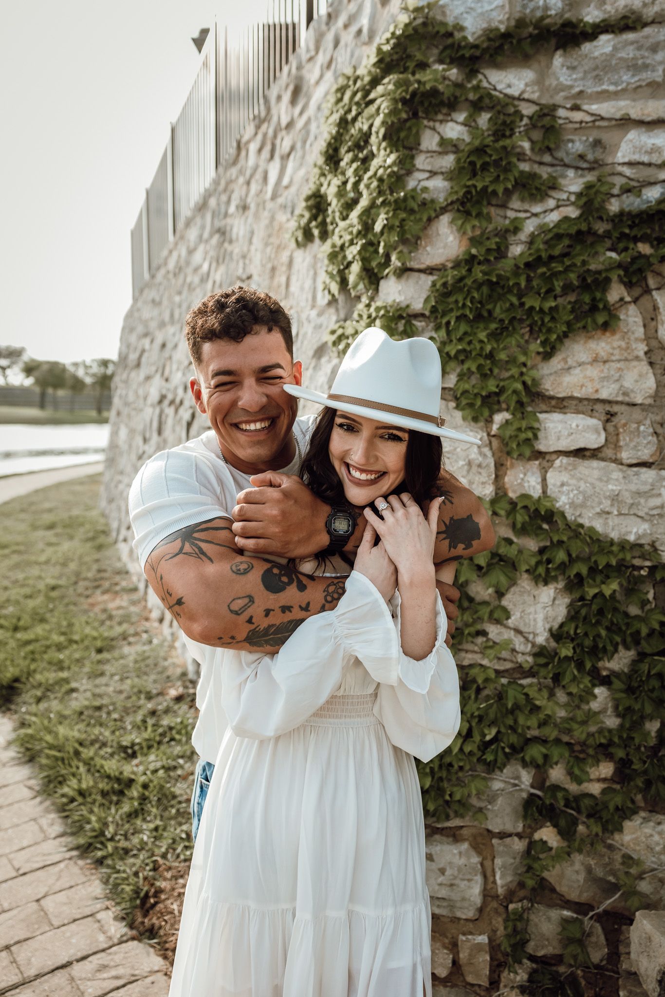 A heartwarming series of candid moments between parent and child wearing matching white dresses against a stone wall.