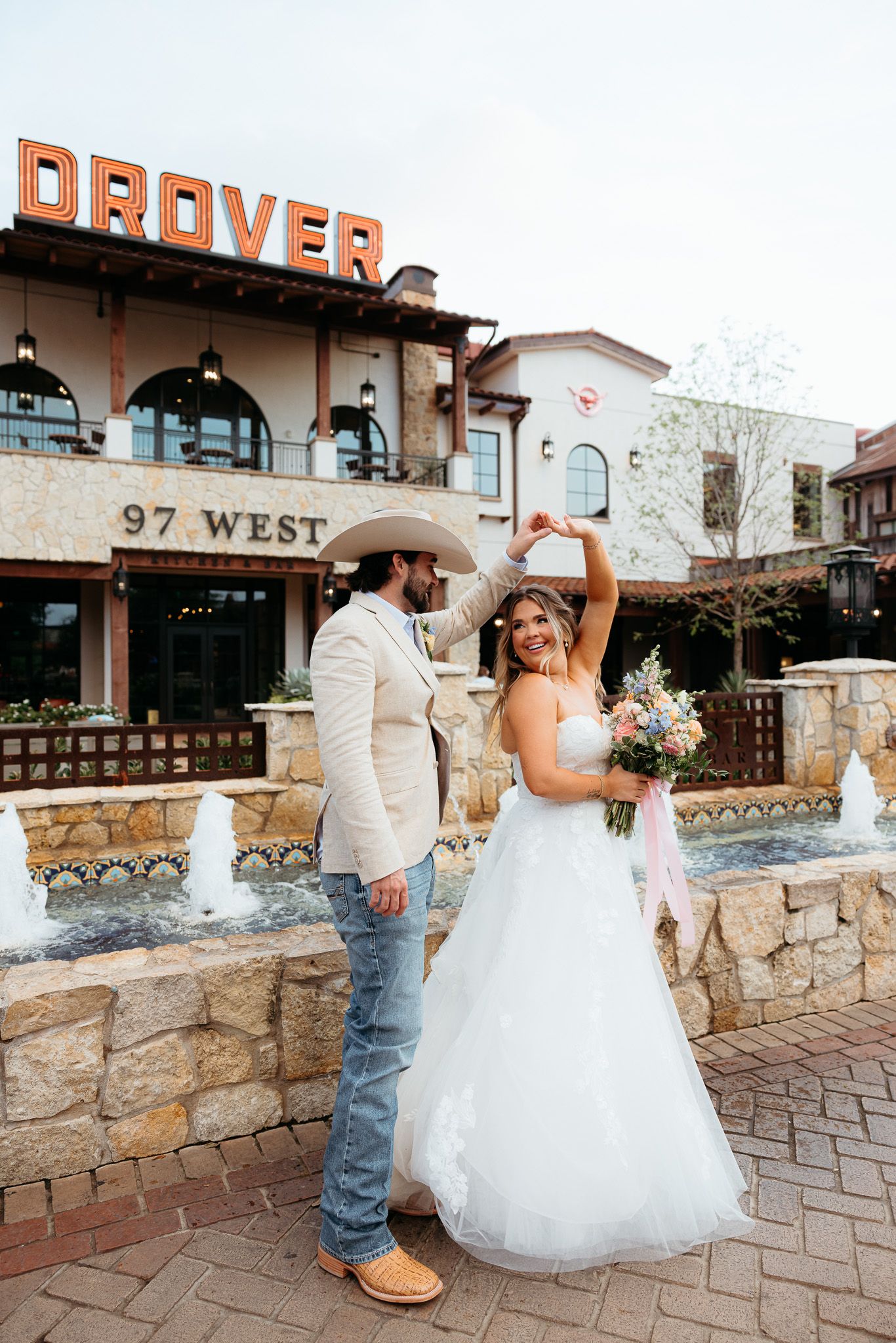 Wedding couple posing outside The Grove venue with rustic stone walls.