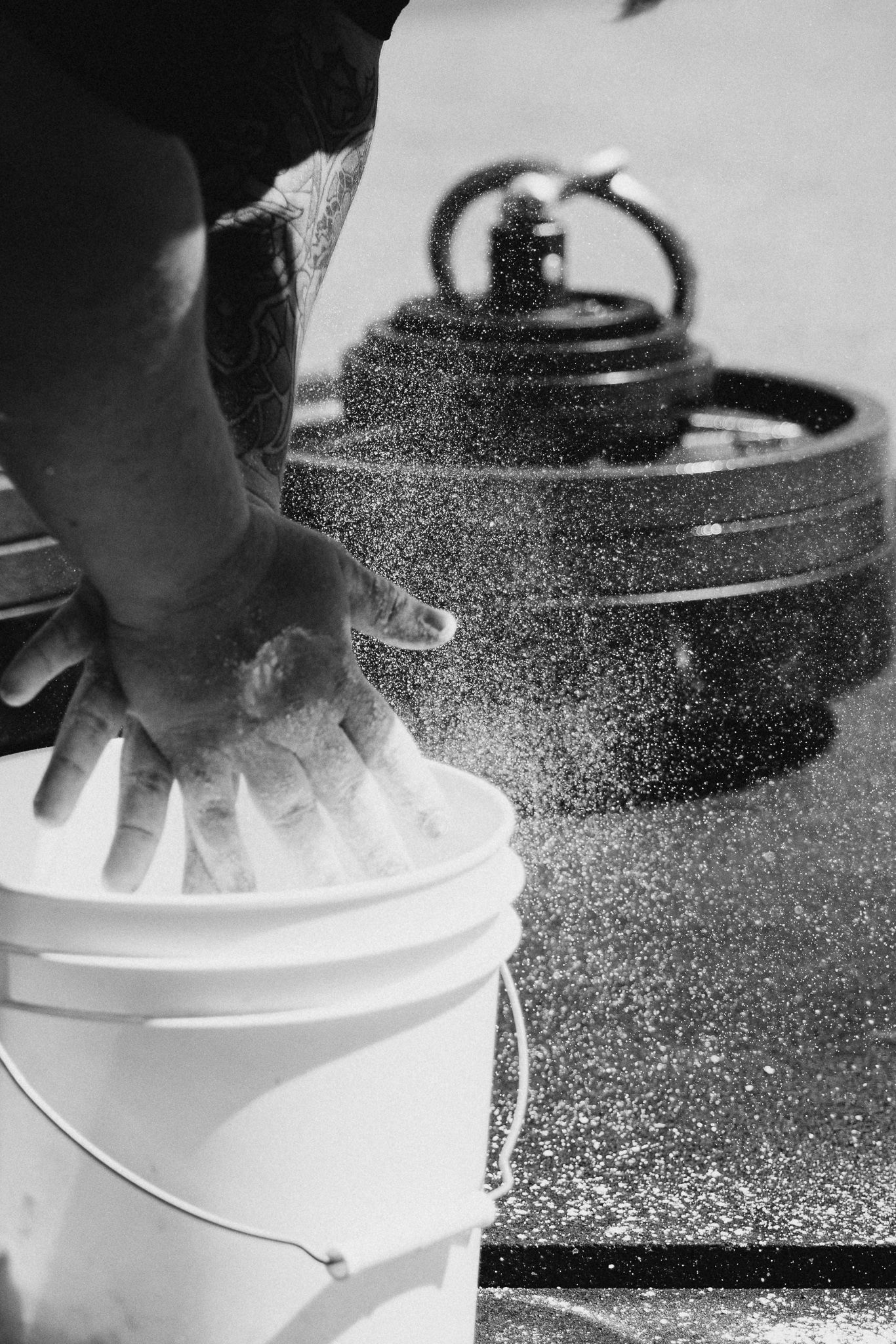 Close-up sequence of chalk dust being applied to athletic equipment from a white bucket.
