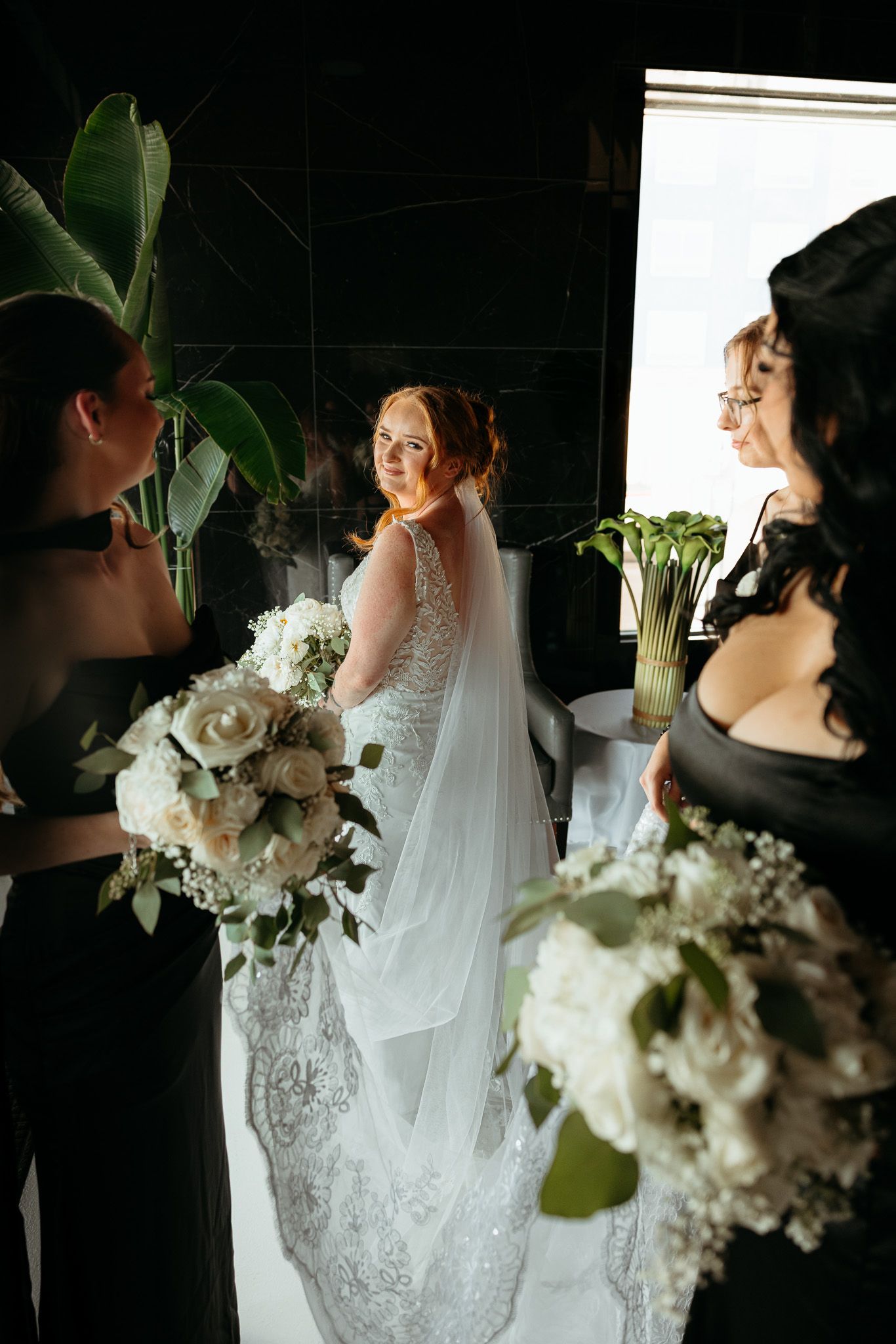 Artistic wedding preparation shots with white floral bouquets in dramatic lighting.