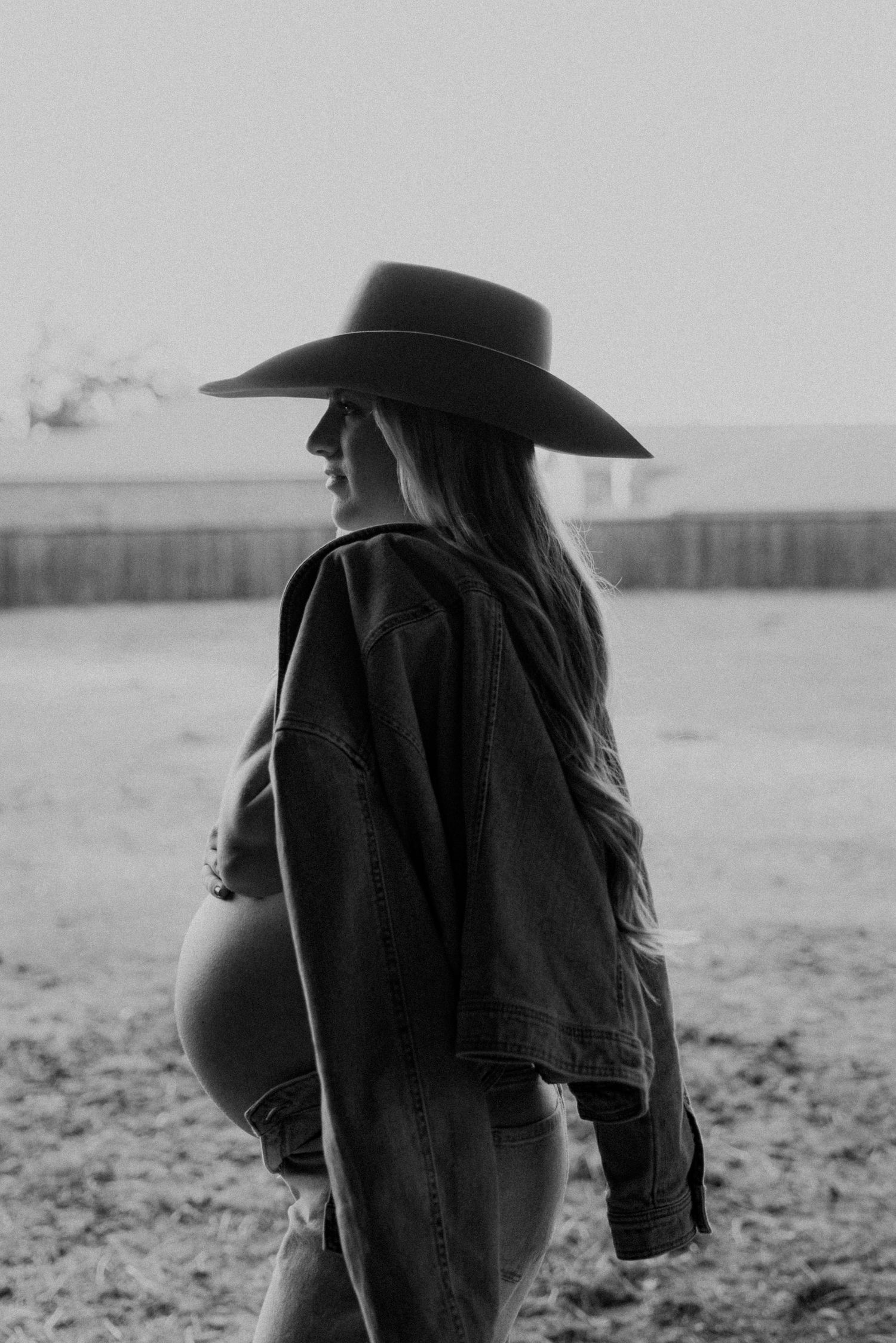 Silhouette of a person in a cowboy hat against an overcast sky.