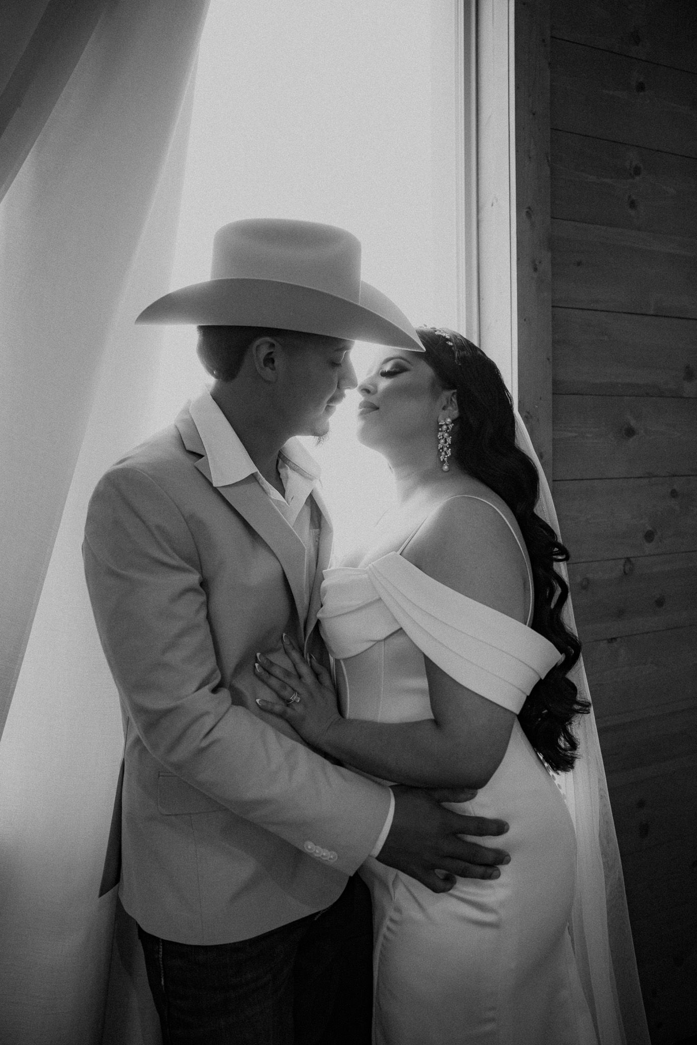 Black and white intimate wedding portraits in dramatic lighting.