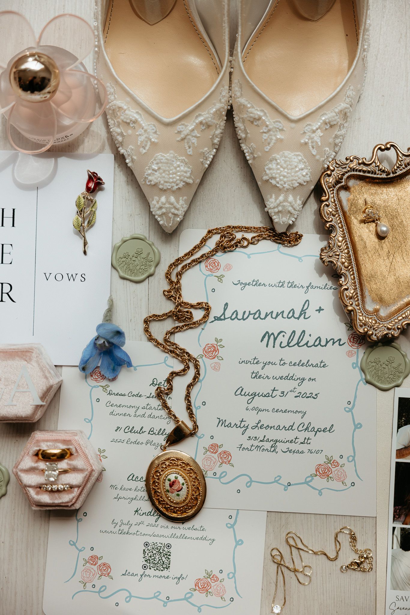 Wedding details flatlay with lace shoes, invitation, vintage jewelry and delicate floral accents in soft neutral tones.