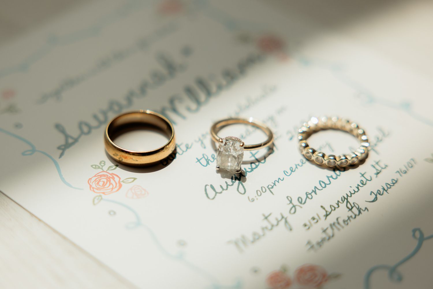 Wedding rings and handwritten vows arranged on white paper.