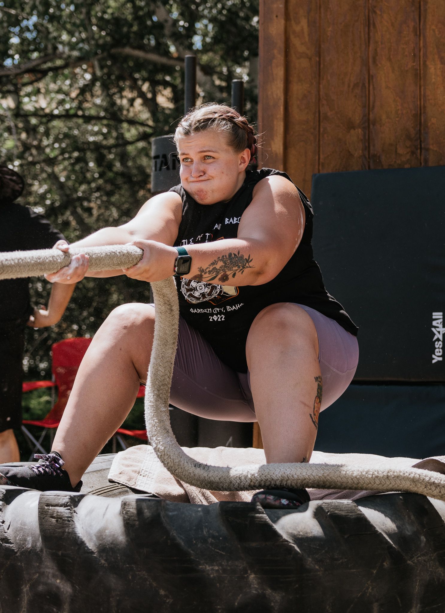Competitor resting between events on competition equipment at an outdoor venue.