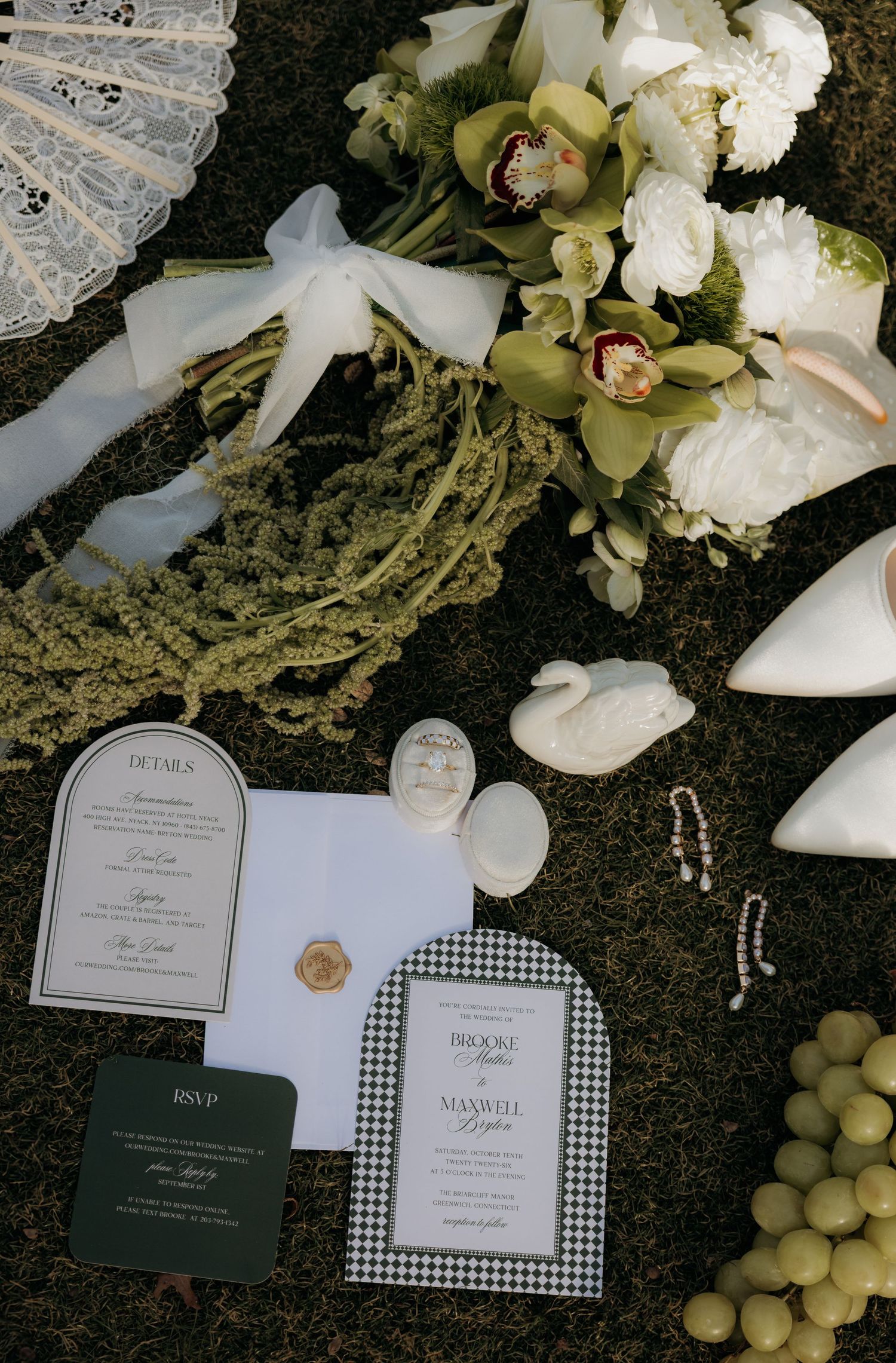 Wedding invitation suite with green orchids and white floral arrangements on dark background.
