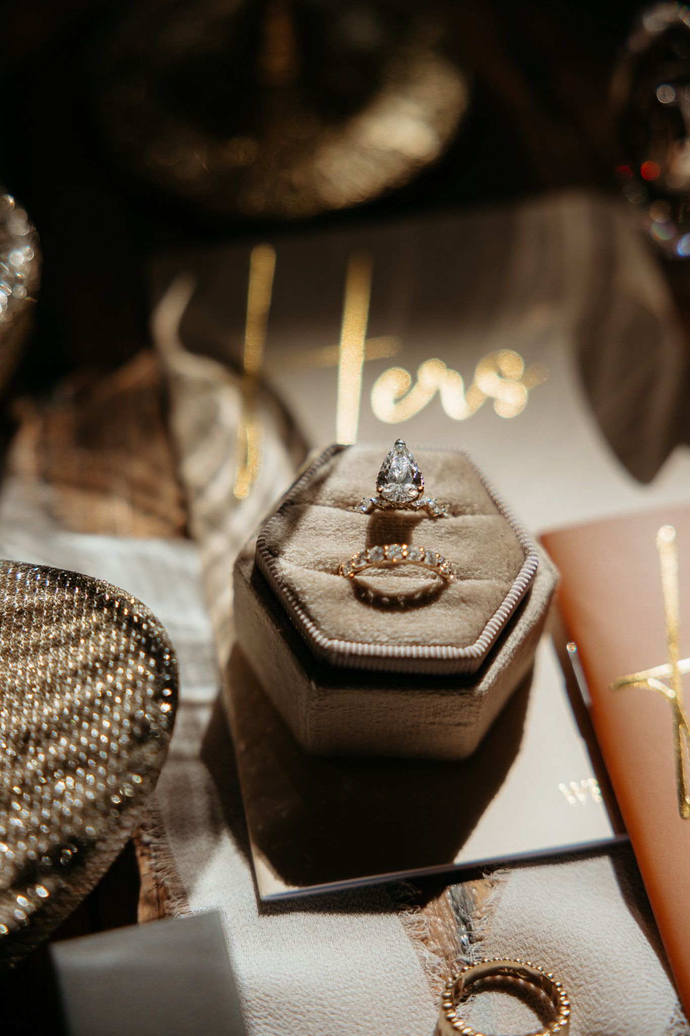 Close-up sequence of wedding rings displayed on dark hexagonal holders with sparkly details.