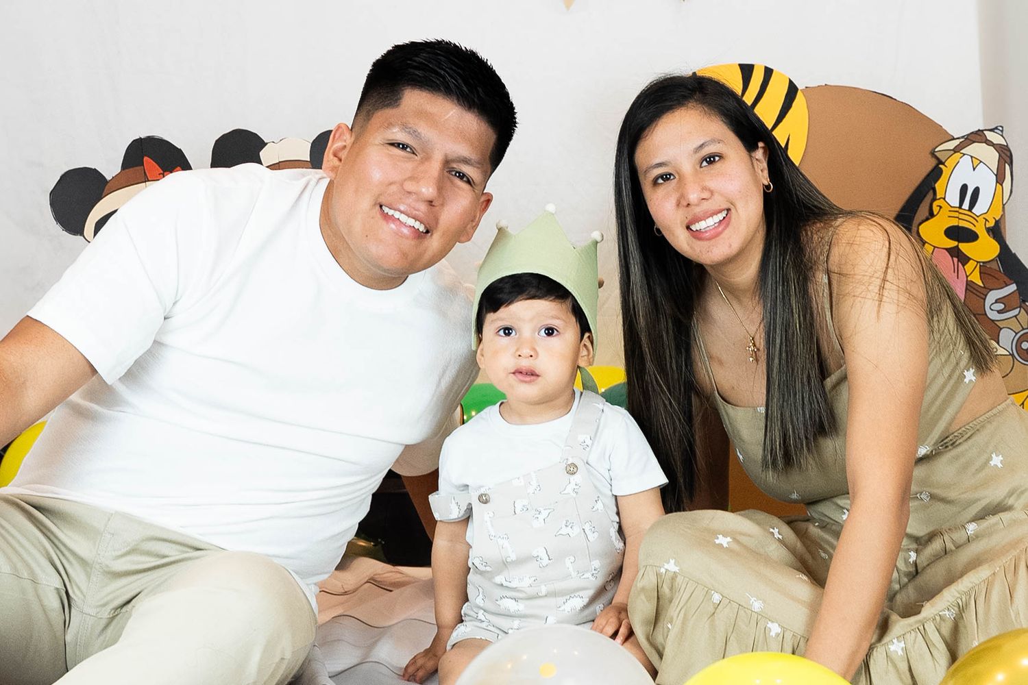 Family relaxing together on white bedding during casual photoshoot.