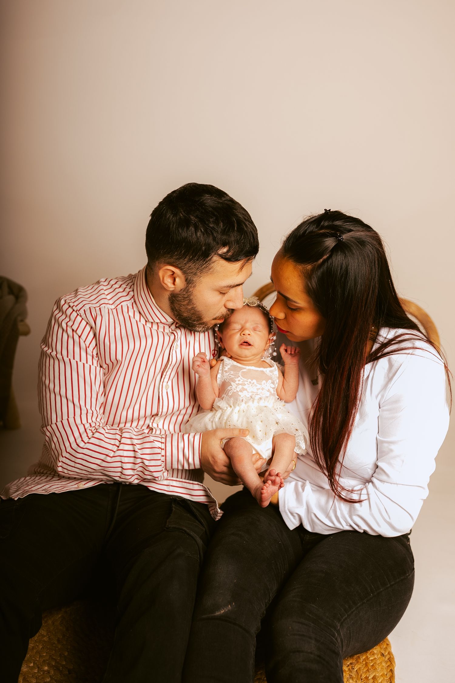 A loving family shares tender moments together in a series of warm, intimate portrait photographs.