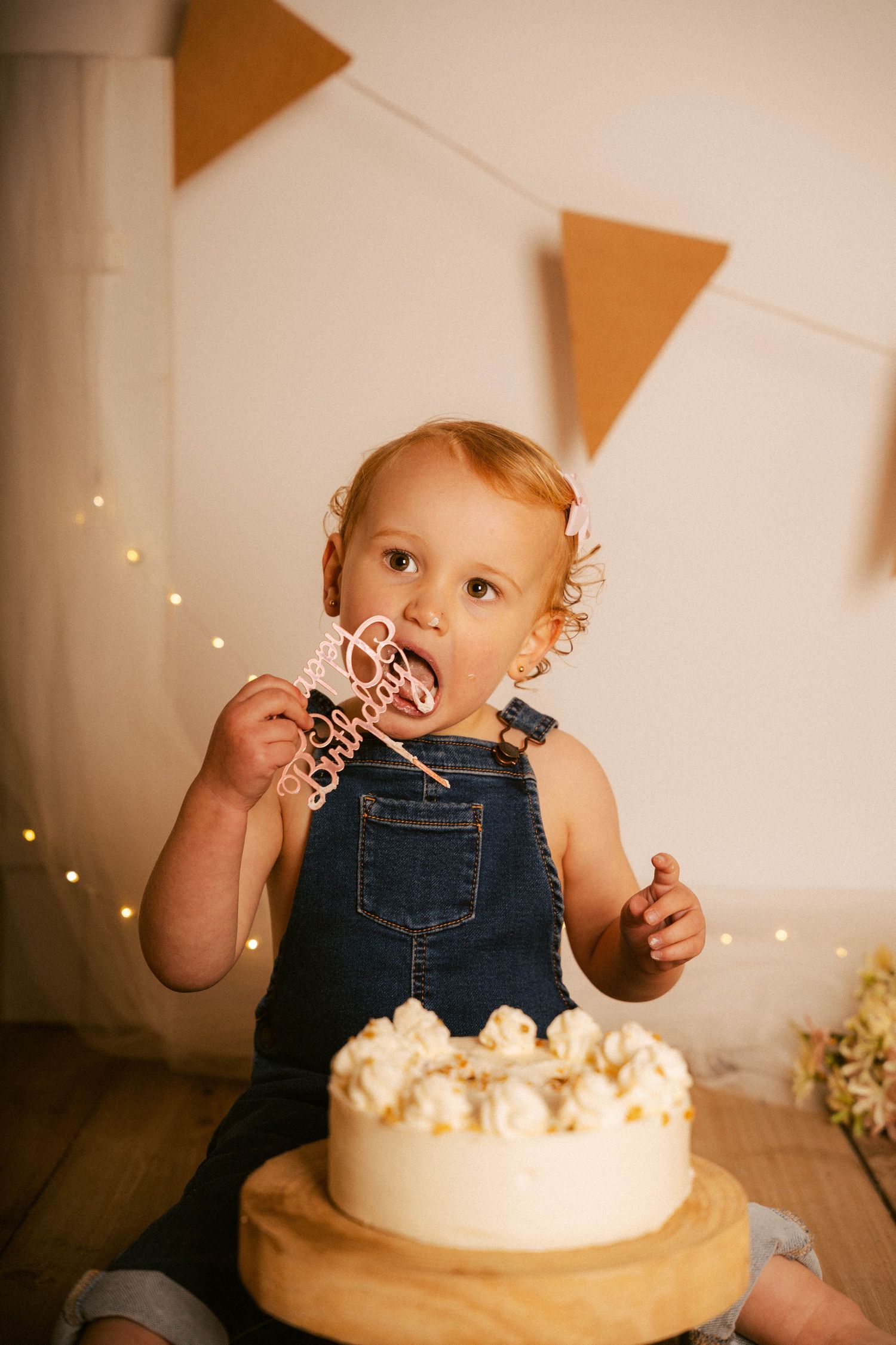 A series of photos showing a small child in denim overalls playing with bubbles and cake during a photo session.