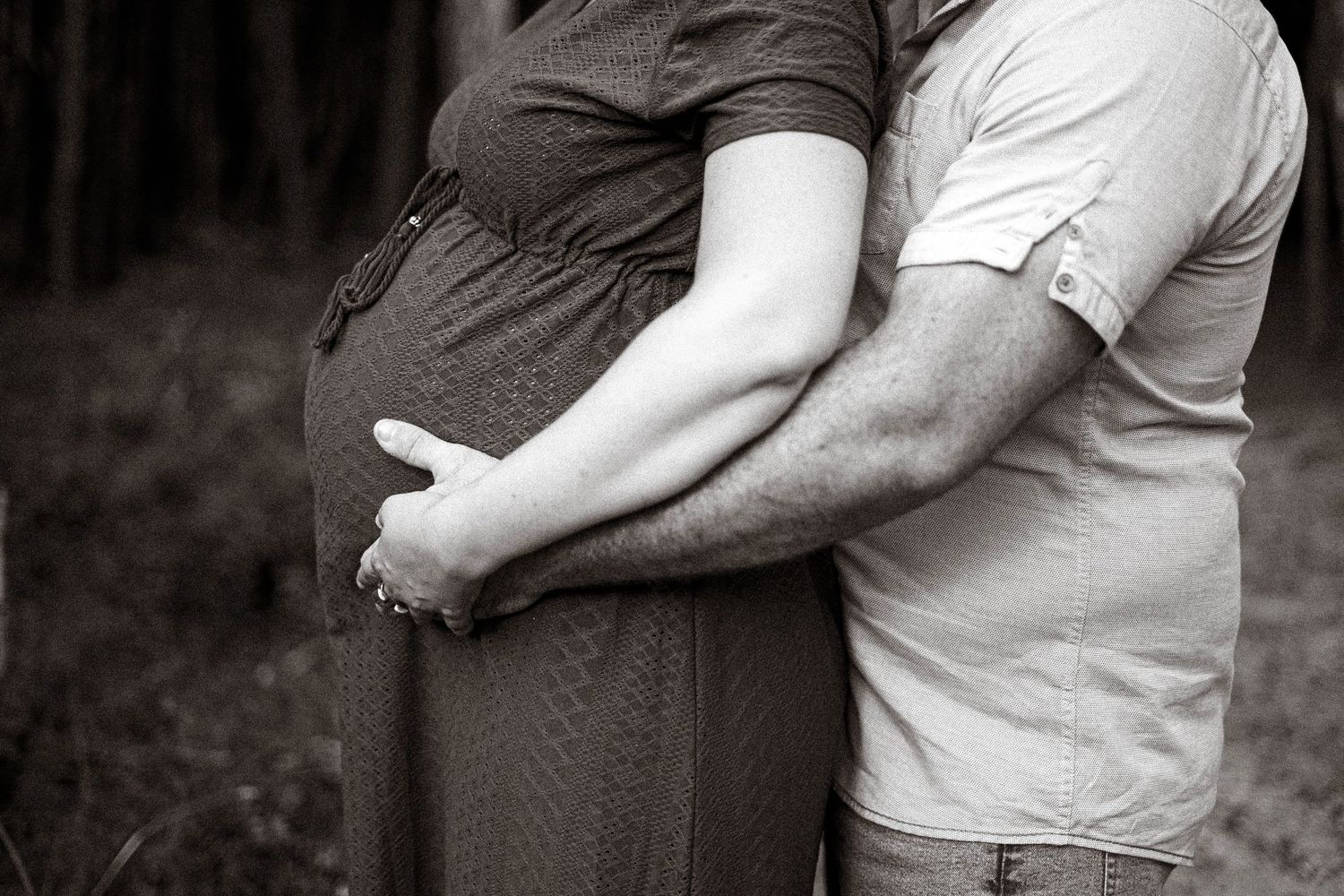 Silhouette of an embracing couple against a dark background.