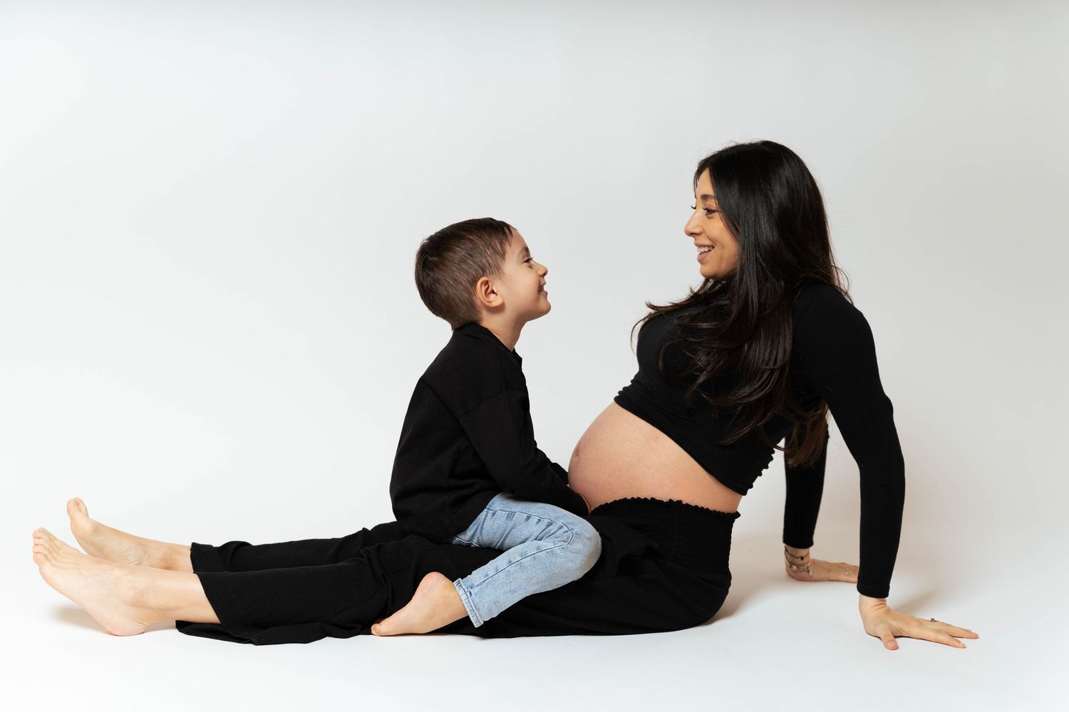 A series of intimate maternity poses showing a family embracing against a white studio backdrop.
