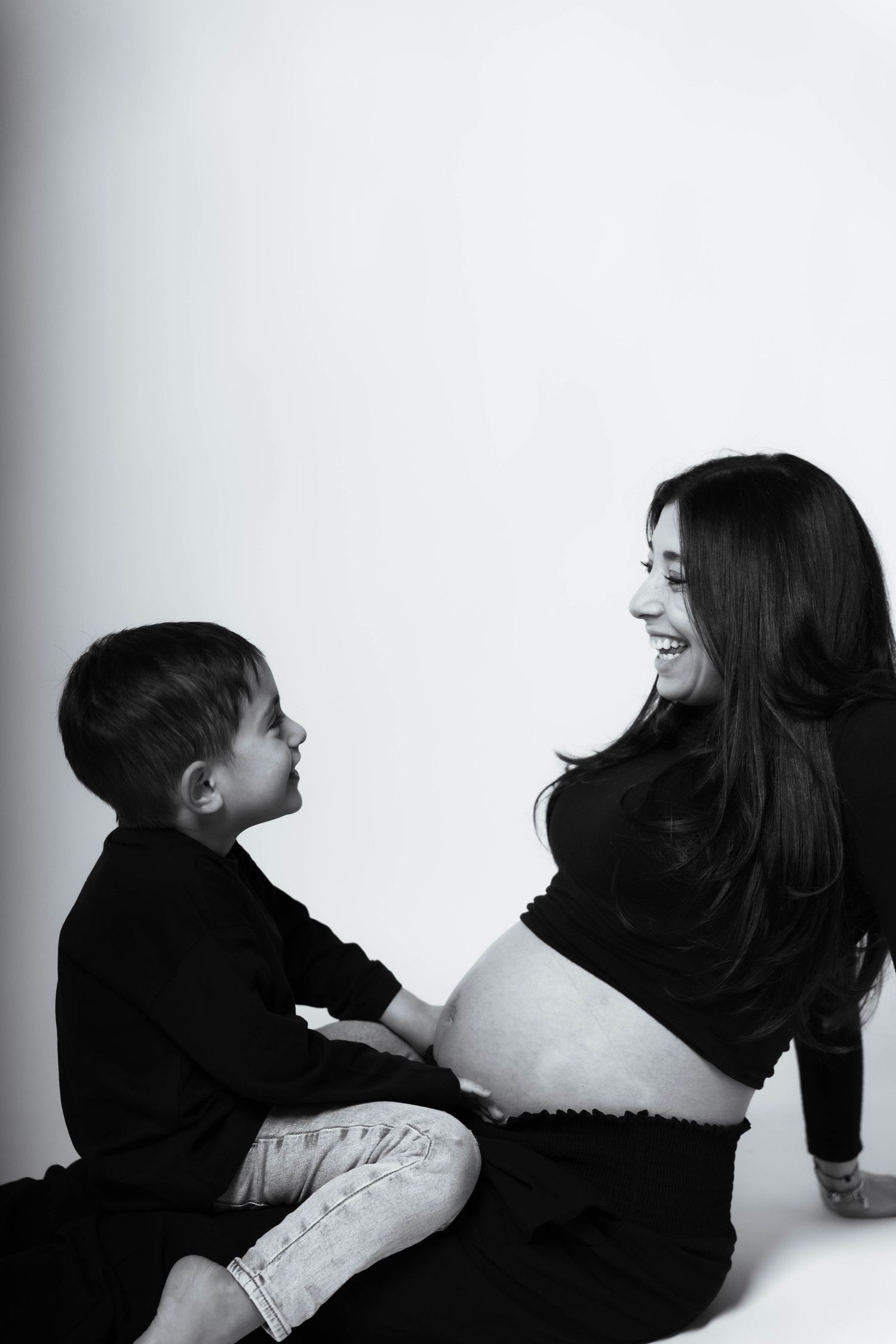 A sequence of black and white photos showing two people in intimate poses against a white background.