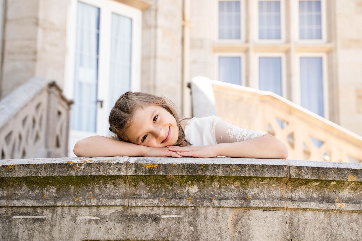 Stone building exterior with multiple windows serves as backdrop for formal portraits.
