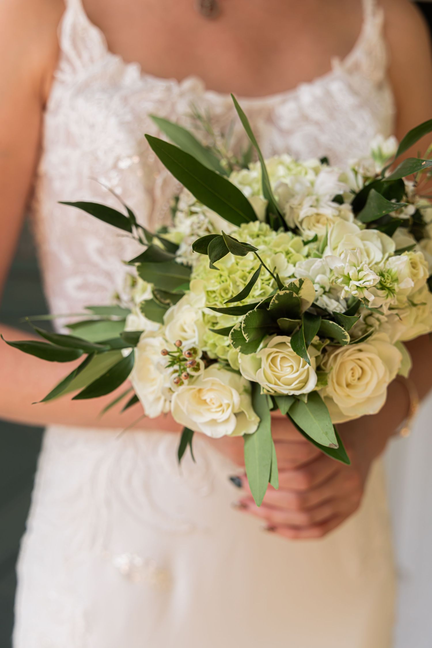 Close-up of a bride’s bouquet with white and green florals, captured as a meaningful wedding detail.