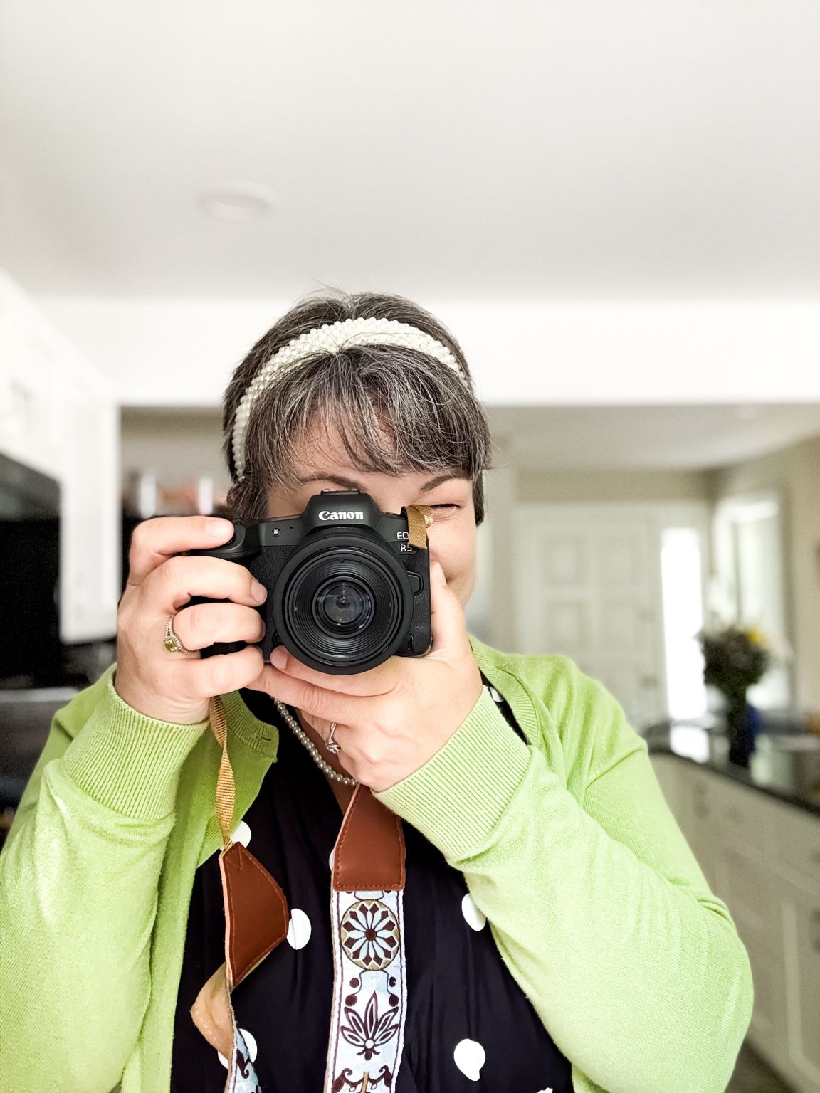 Katelyn Lucas holding a camera for a photographer self-portrait, representing visual storytelling and brand photography.