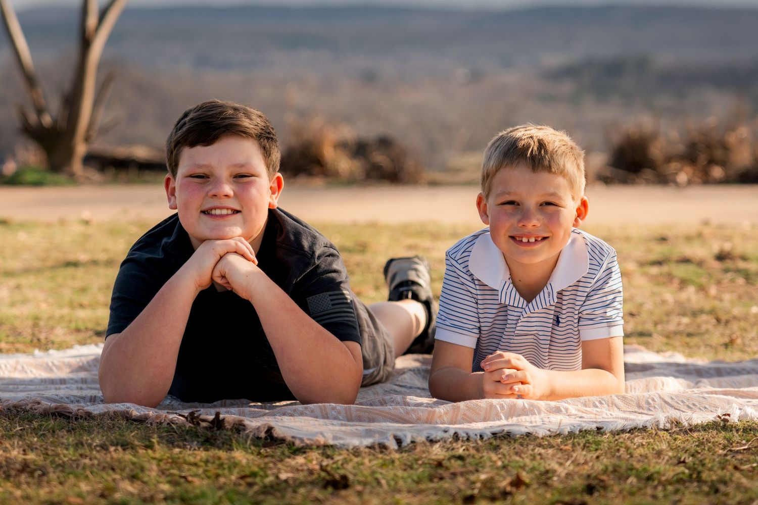 Brothers laying on blanket smiling at camera during outdoor family photos at Bell Park Greenwood Arkansas