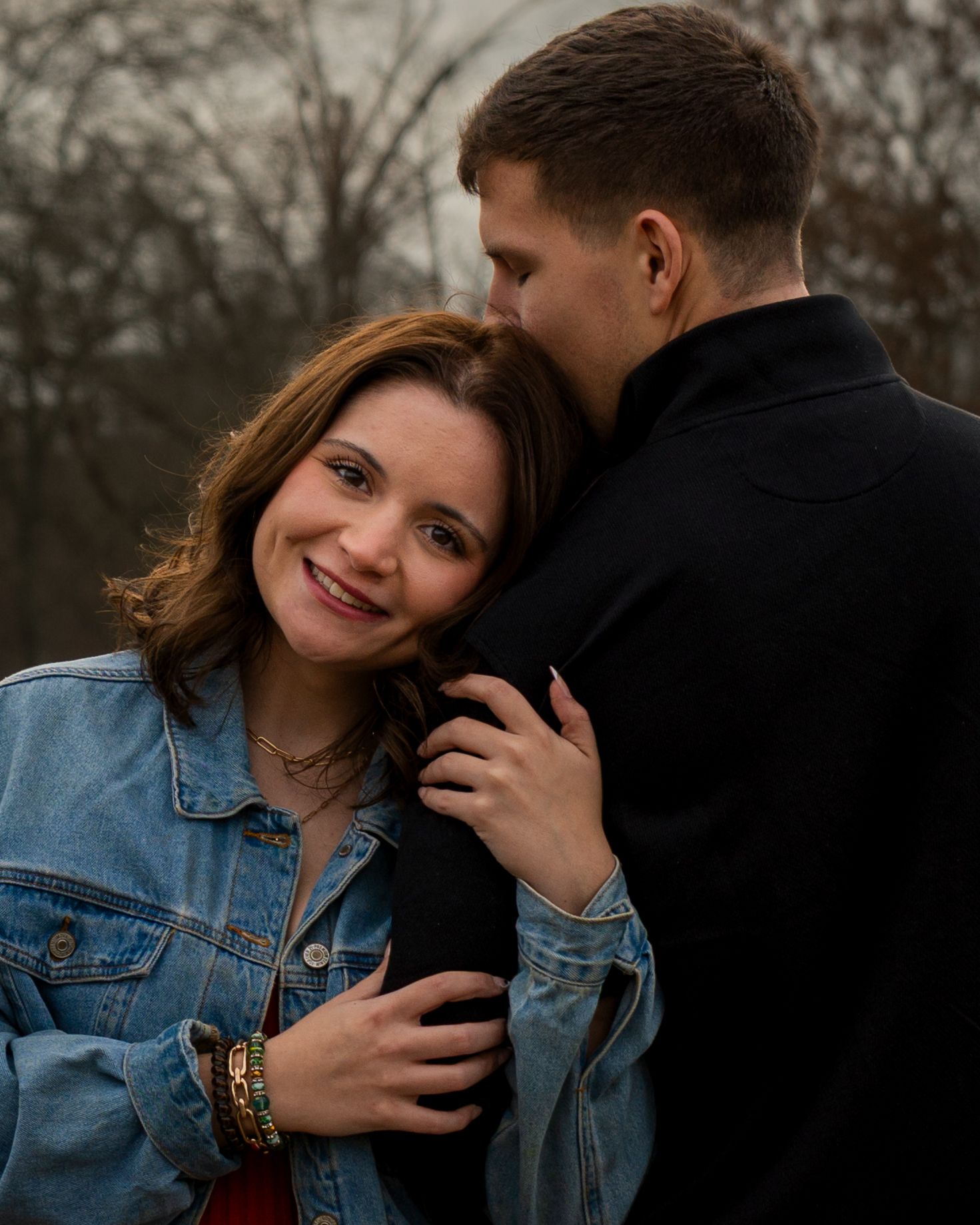 Candid couple portrait with woman smiling at camera while hugging partner at Barling City Park