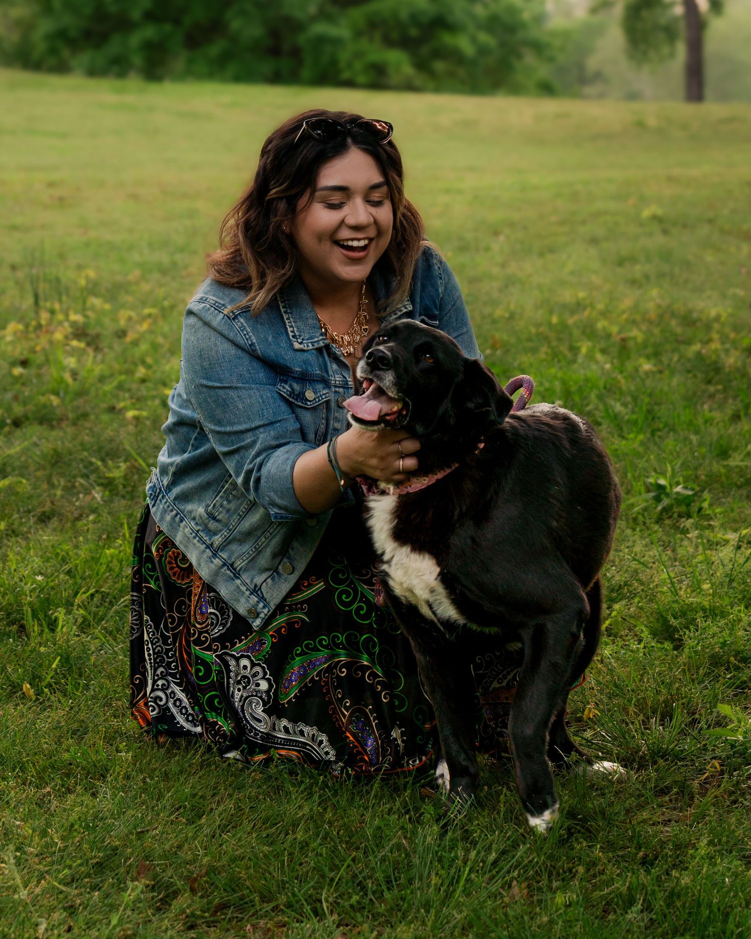 Woman smiling and holding her dog during outdoor portrait session at Fort Smith National Historic Site in Fort Smith Arkansas