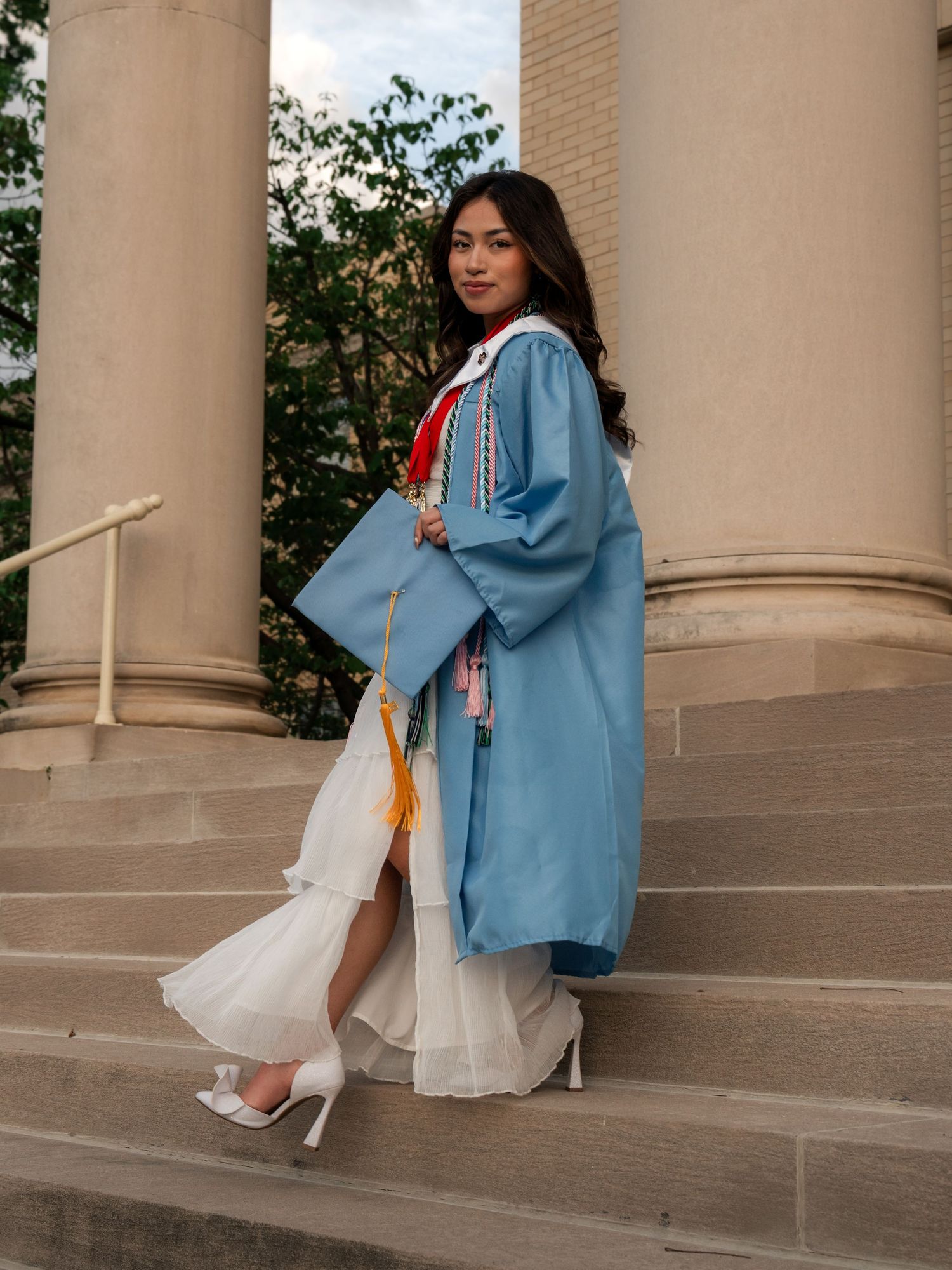 Southside High School senior in cap and gown sitting on steps holding graduation cap in Fort Smith Arkansas