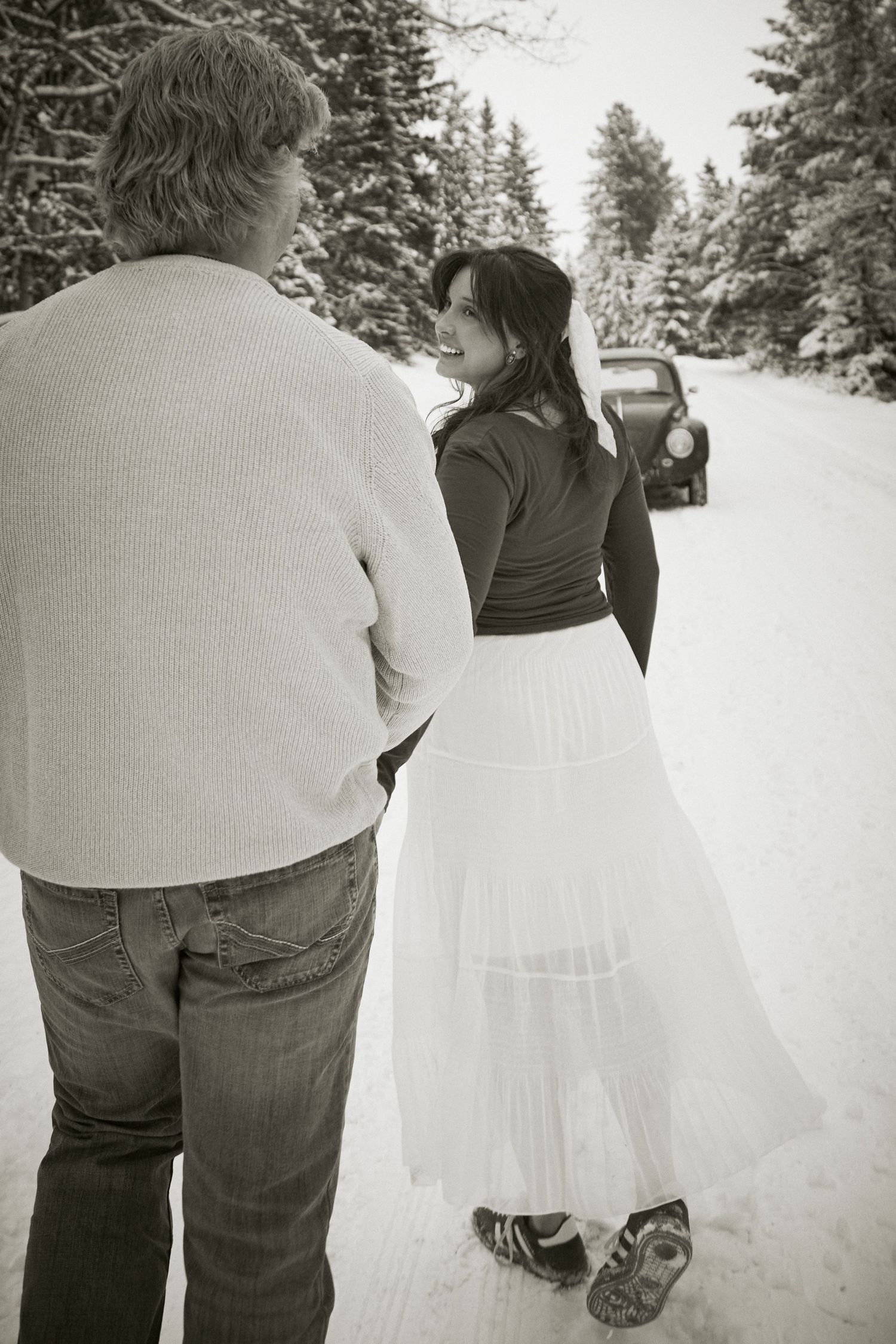 A series of black and white photos showing a couple walking together in a snowy winter landscape.