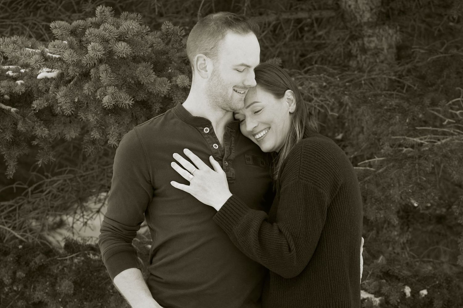 A romantic black and white photo series showing a couple embracing and sharing intimate moments in nature.