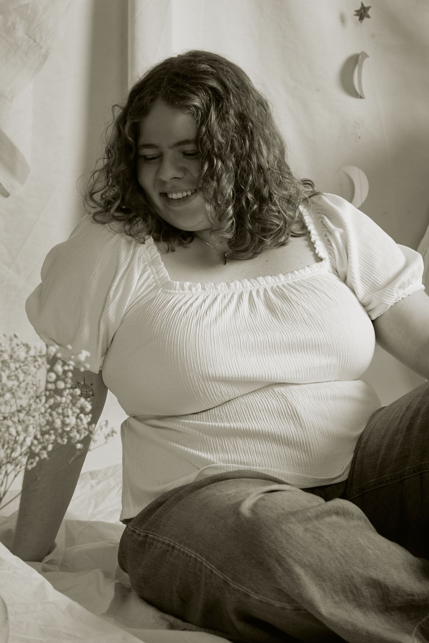 A series of black and white photos showing a person in a white sweater and jeans lounging on a couch in different poses.