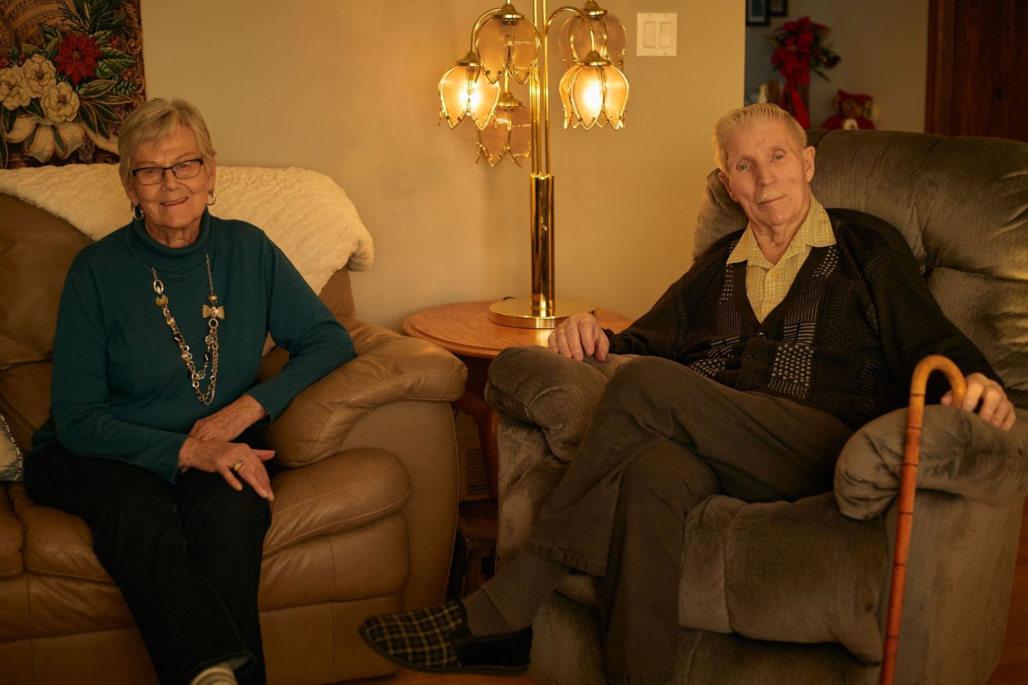 A group of elderly people sitting on couches in a living room during what appears to be a social gathering.