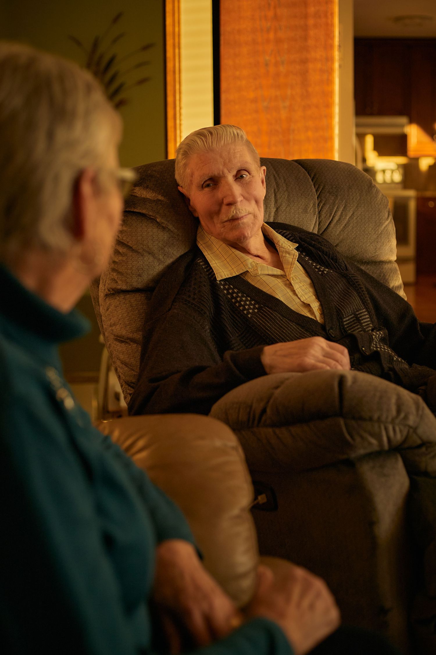 A sequence of shots showing a person relaxing in a dimly lit room with warm lighting and a cozy atmosphere.