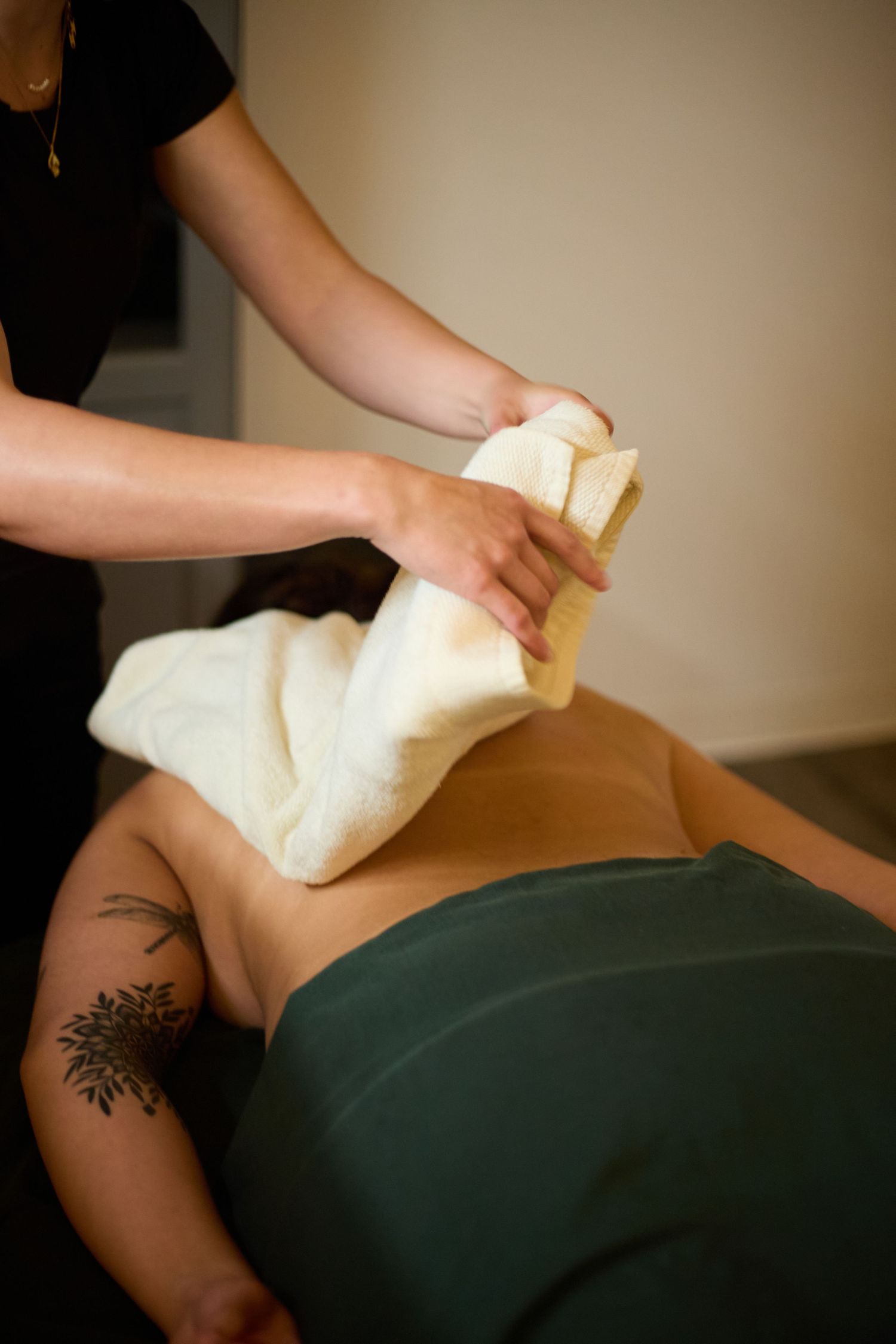 Massage therapist using white towel techniques during a spa treatment.